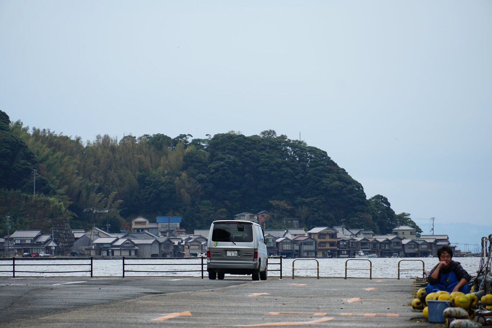 Mazda Bongo campervan parked at Ine harbor with the funaya-lined bay stretching into the distance