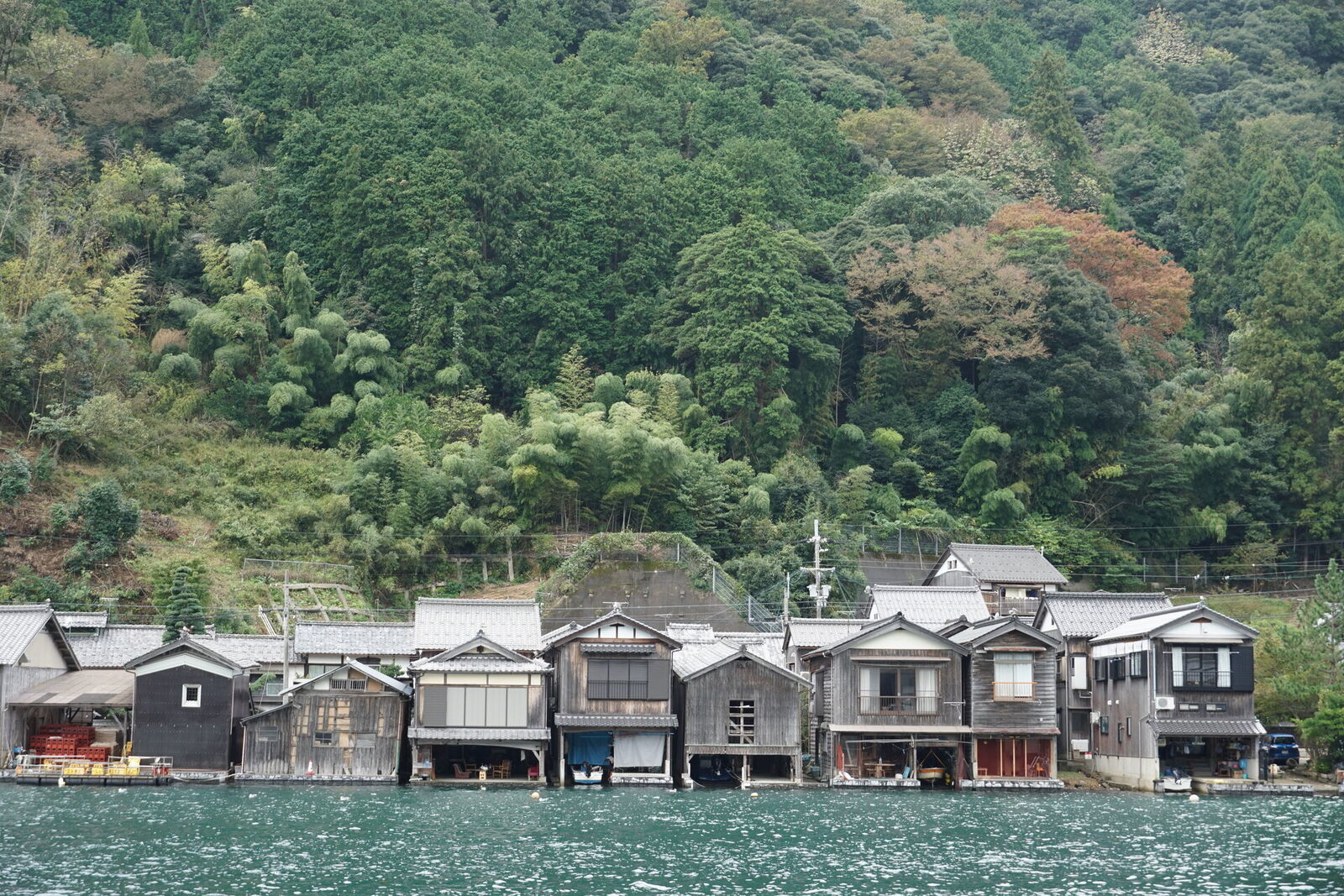Another section of funaya boathouses from the water, showing the variety of styles and ages of the waterfront buildings