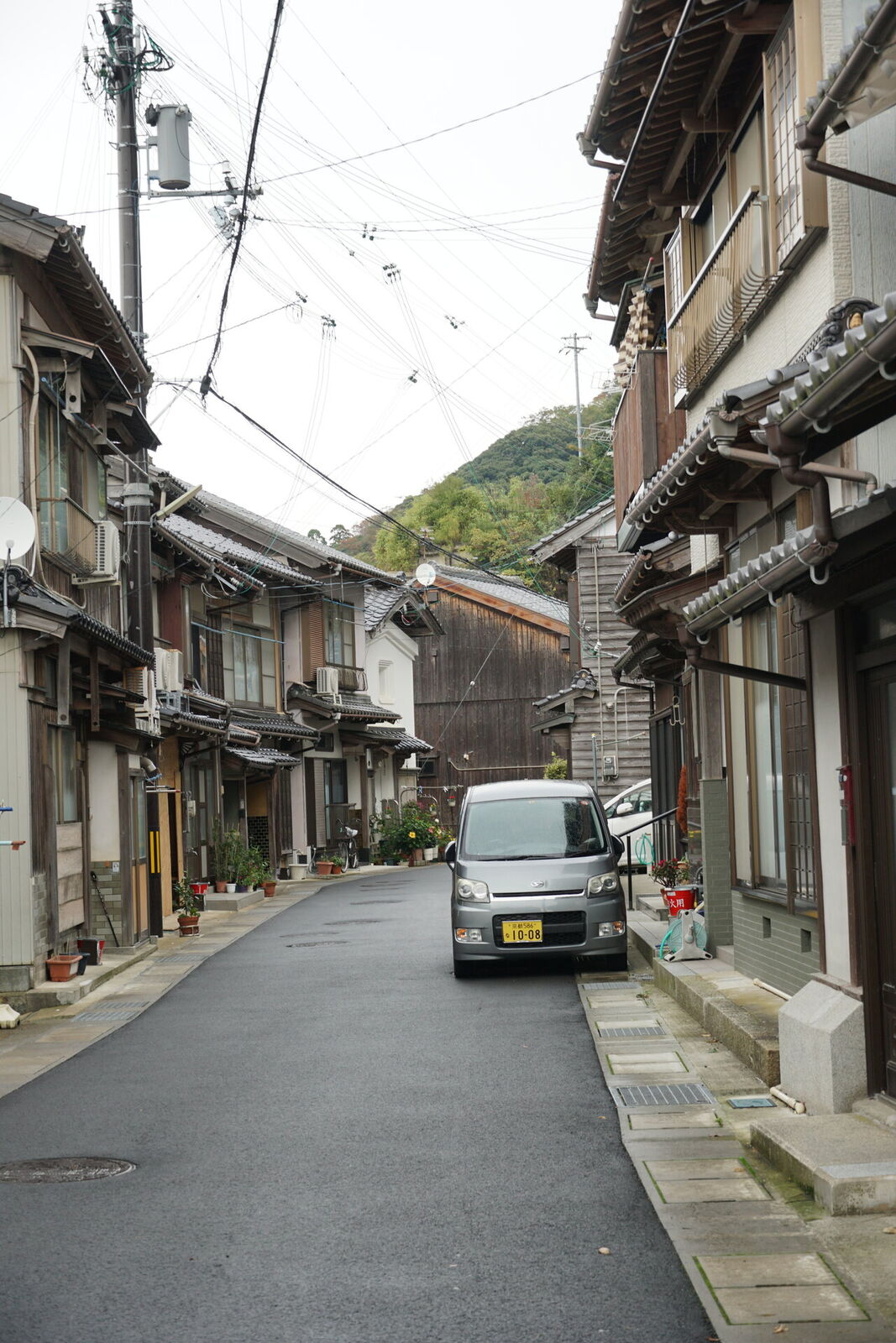 Narrow village street winding between traditional wooden houses in Ine