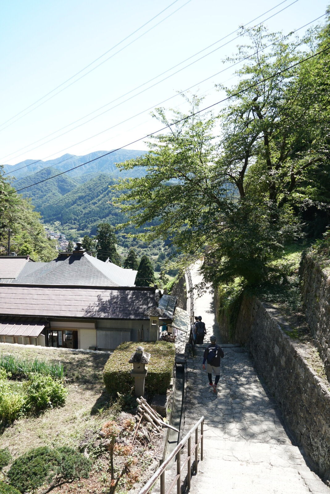 Looking past temple rooftops down into the valley, showing the height gained during the climb
