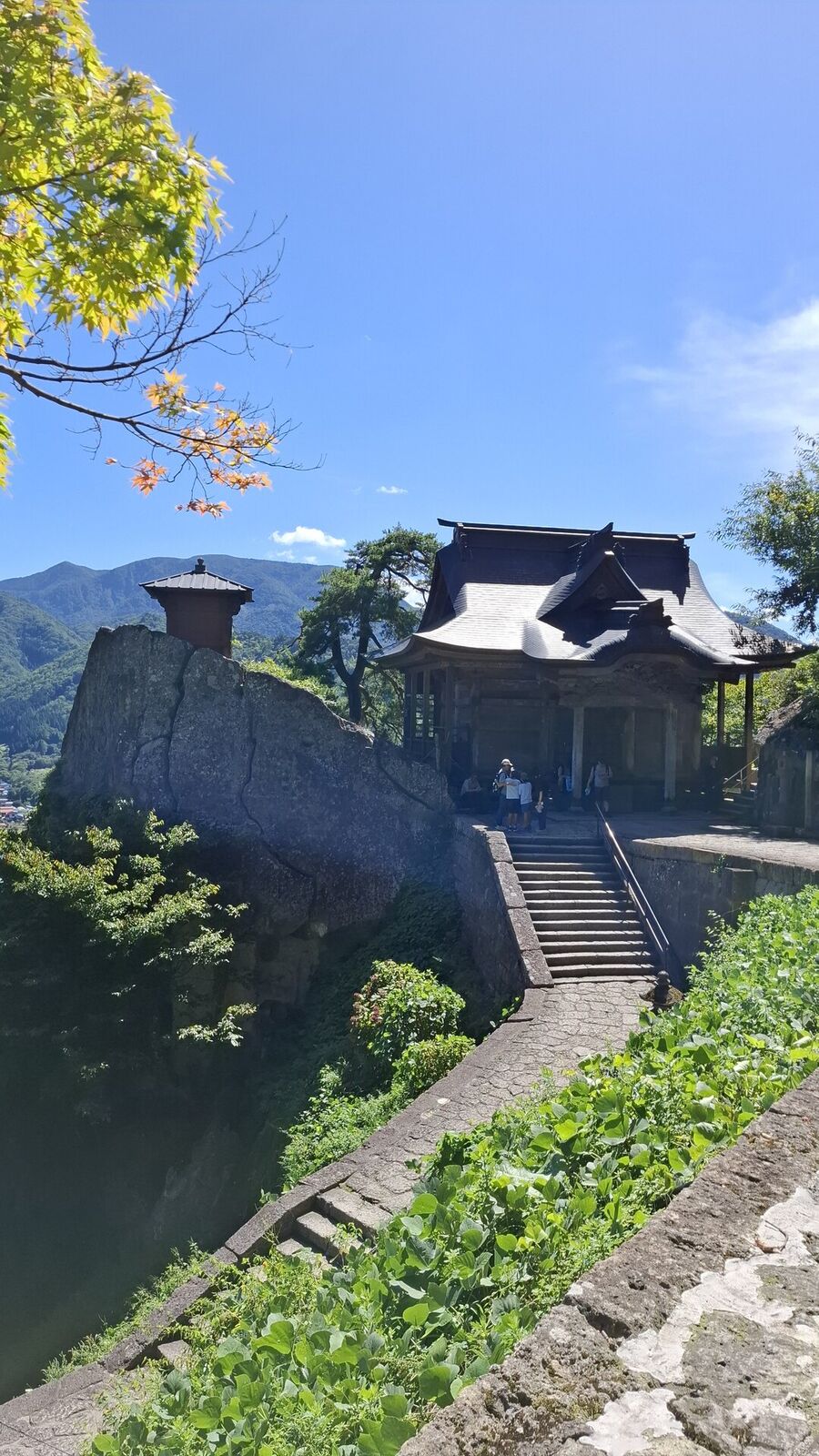 The summit area with its temple buildings perched on the mountain, visitors exploring the ancient structures