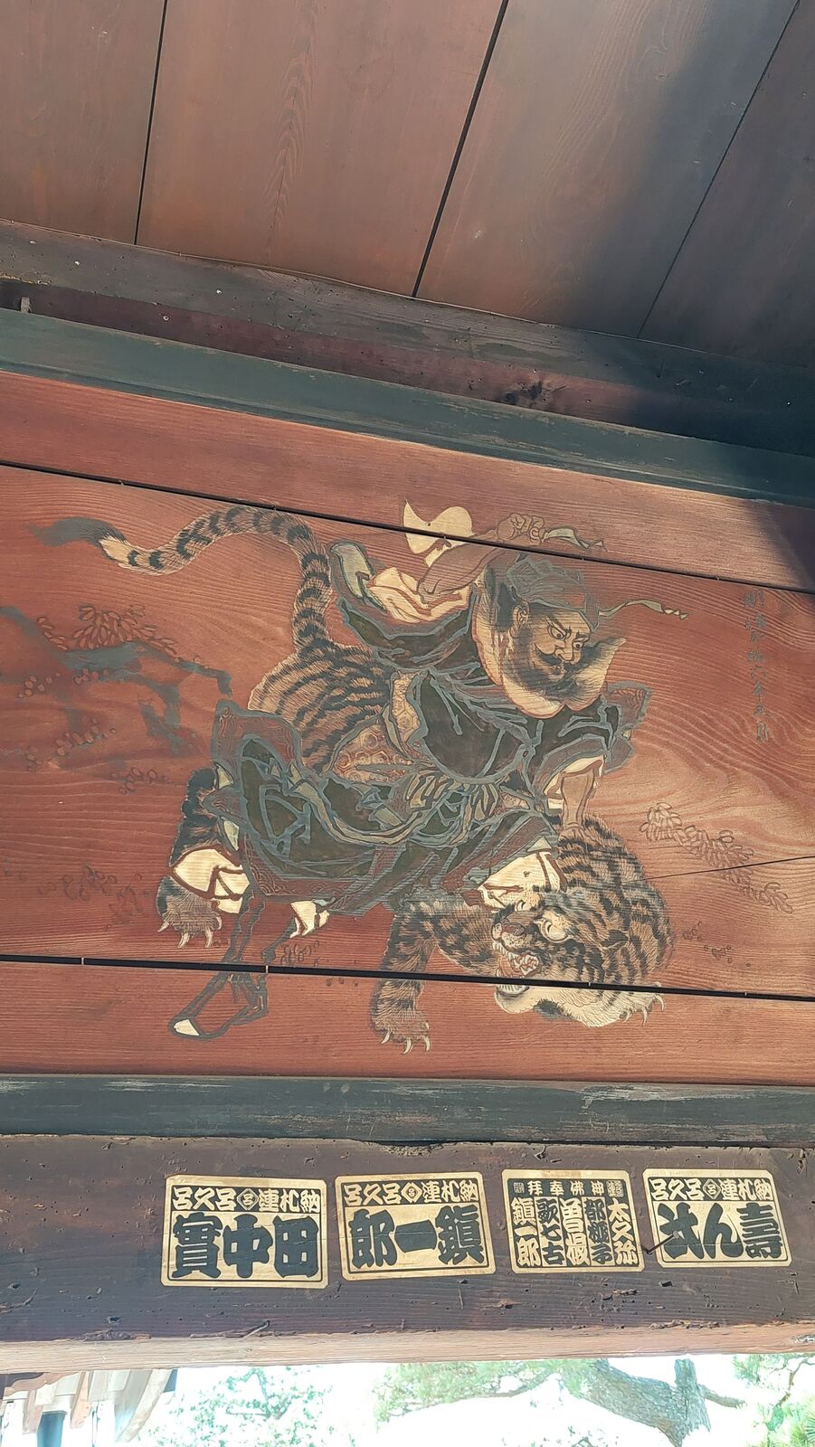 Painted ceiling panel at Chionji showing a fierce warrior riding a tiger, detailed traditional Japanese painting on aged wooden boards