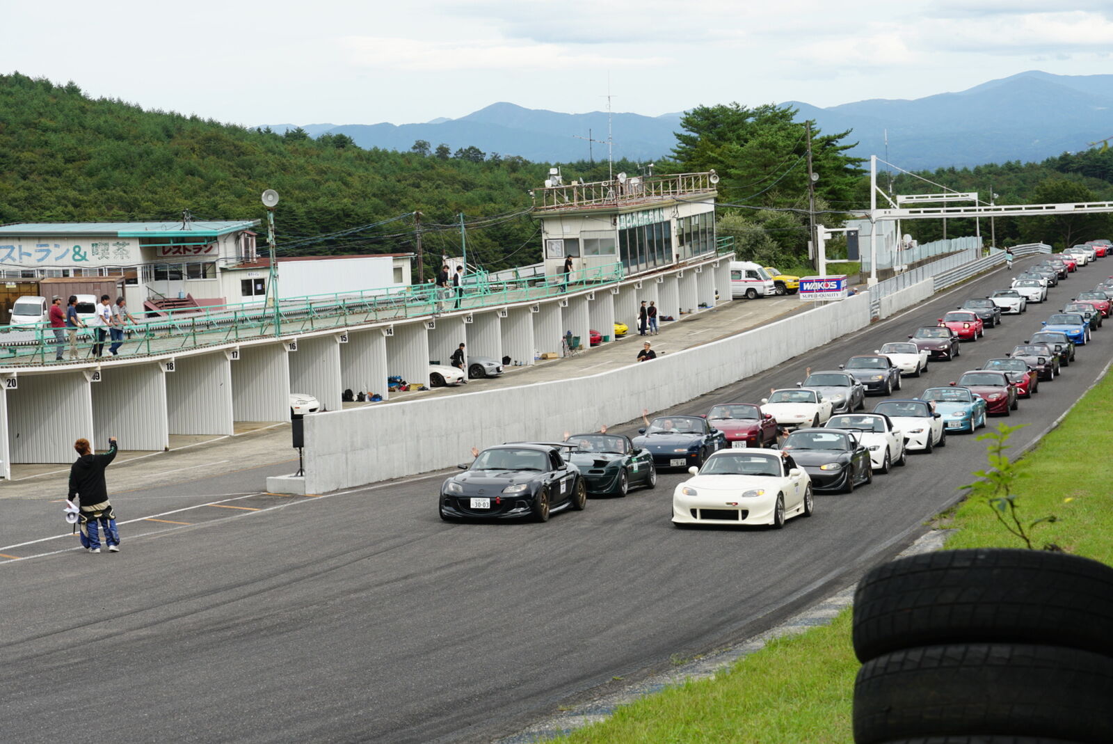 Ebisu Circuit main straight with sports cars and mountains
