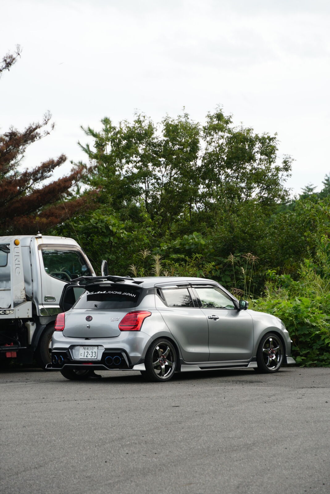 Silver Suzuki Swift Sport rear view with aftermarket wheels and lowered suspension