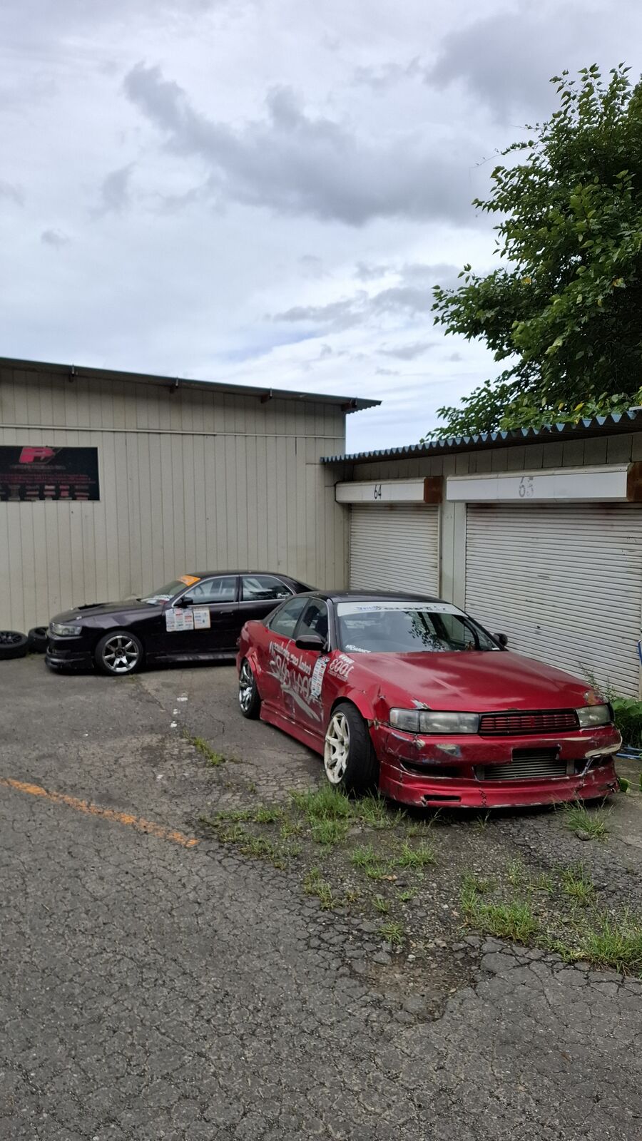 Red car parked in the workshop yard area