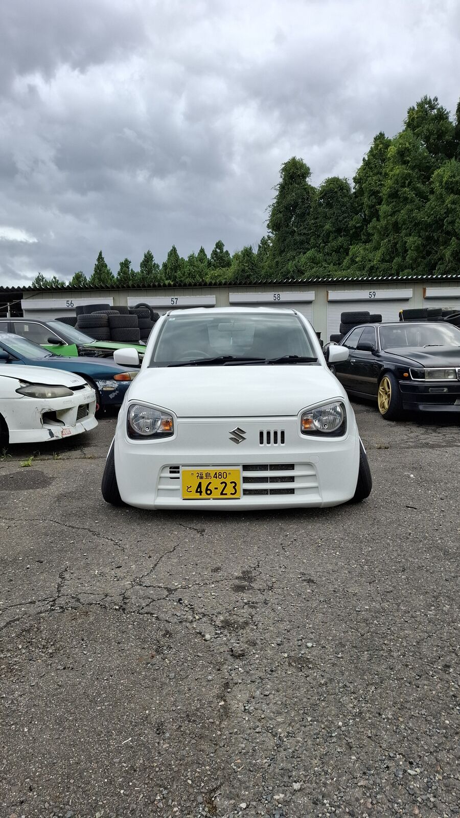 White Suzuki kei truck with yellow plate in the circuit lot