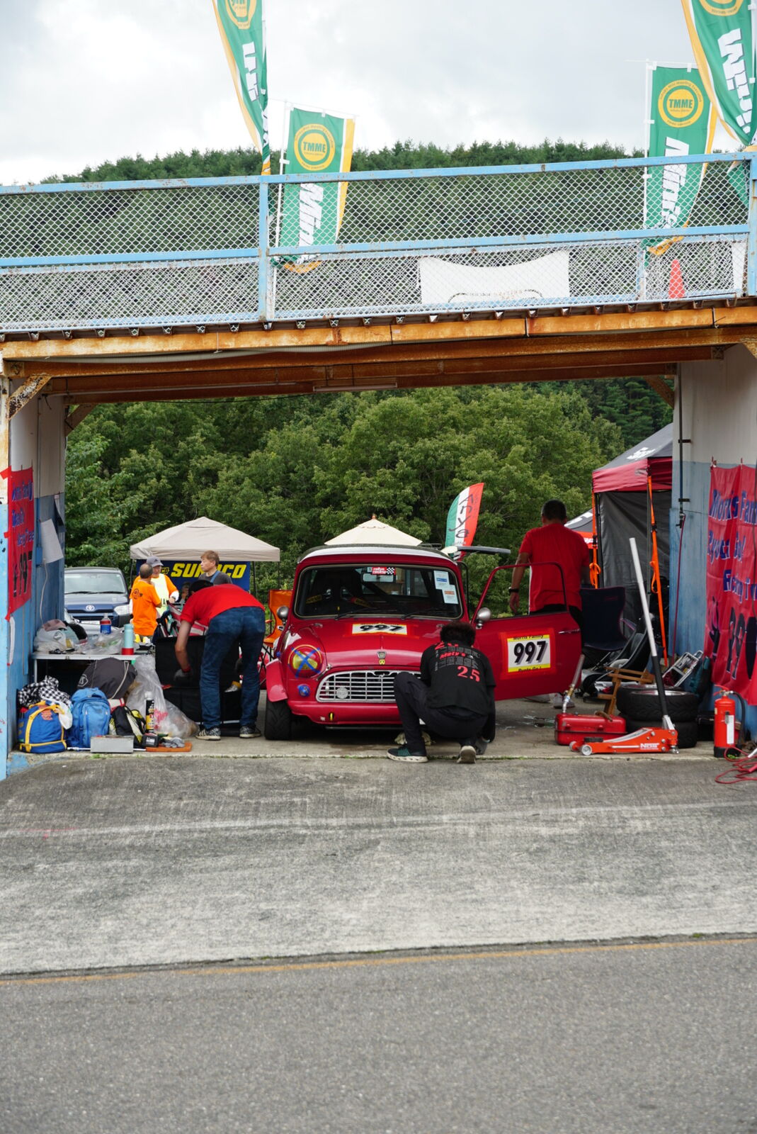 Red car in the pit staging area preparing for a session