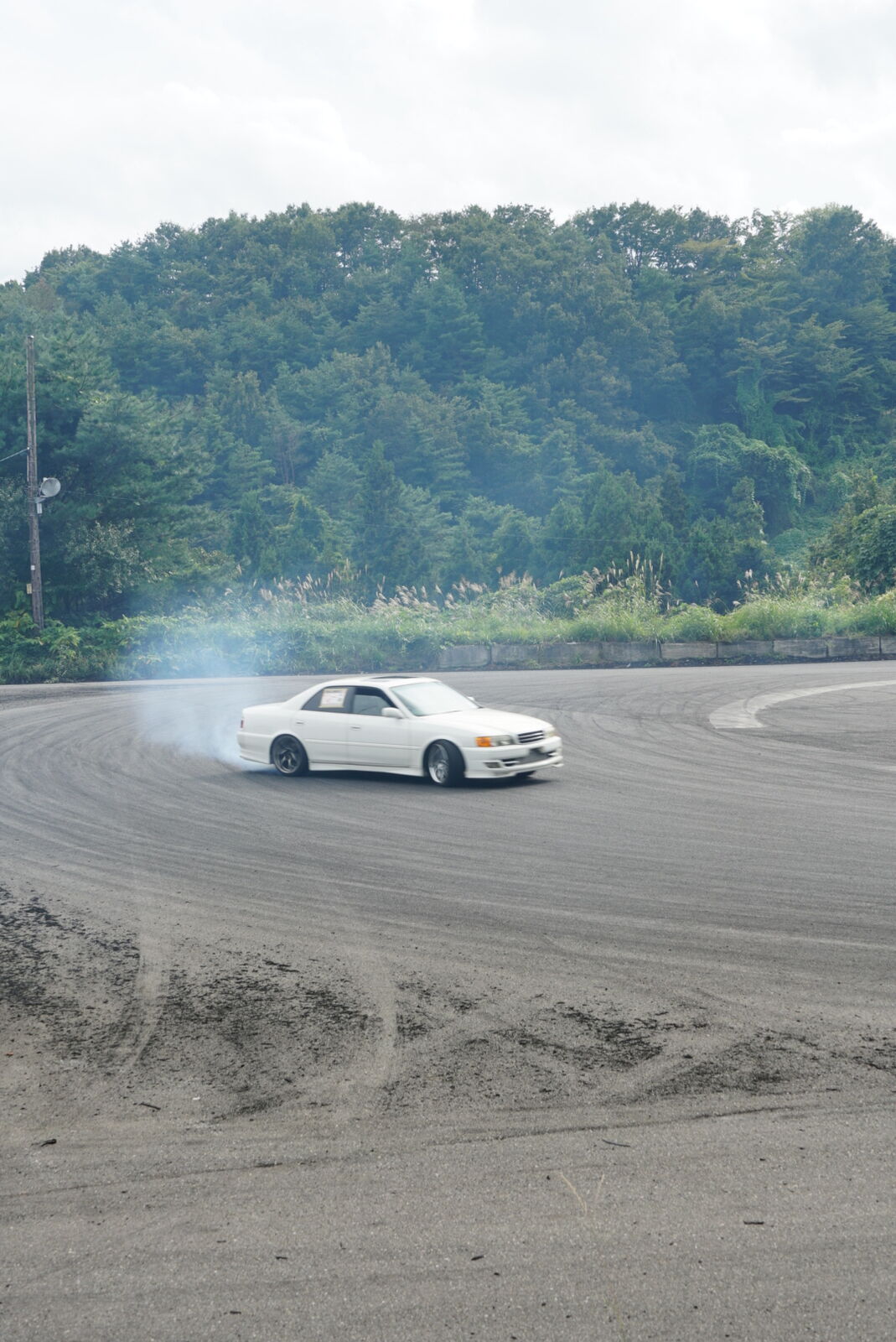Car fully sideways in a cloud of tire smoke on the drift course