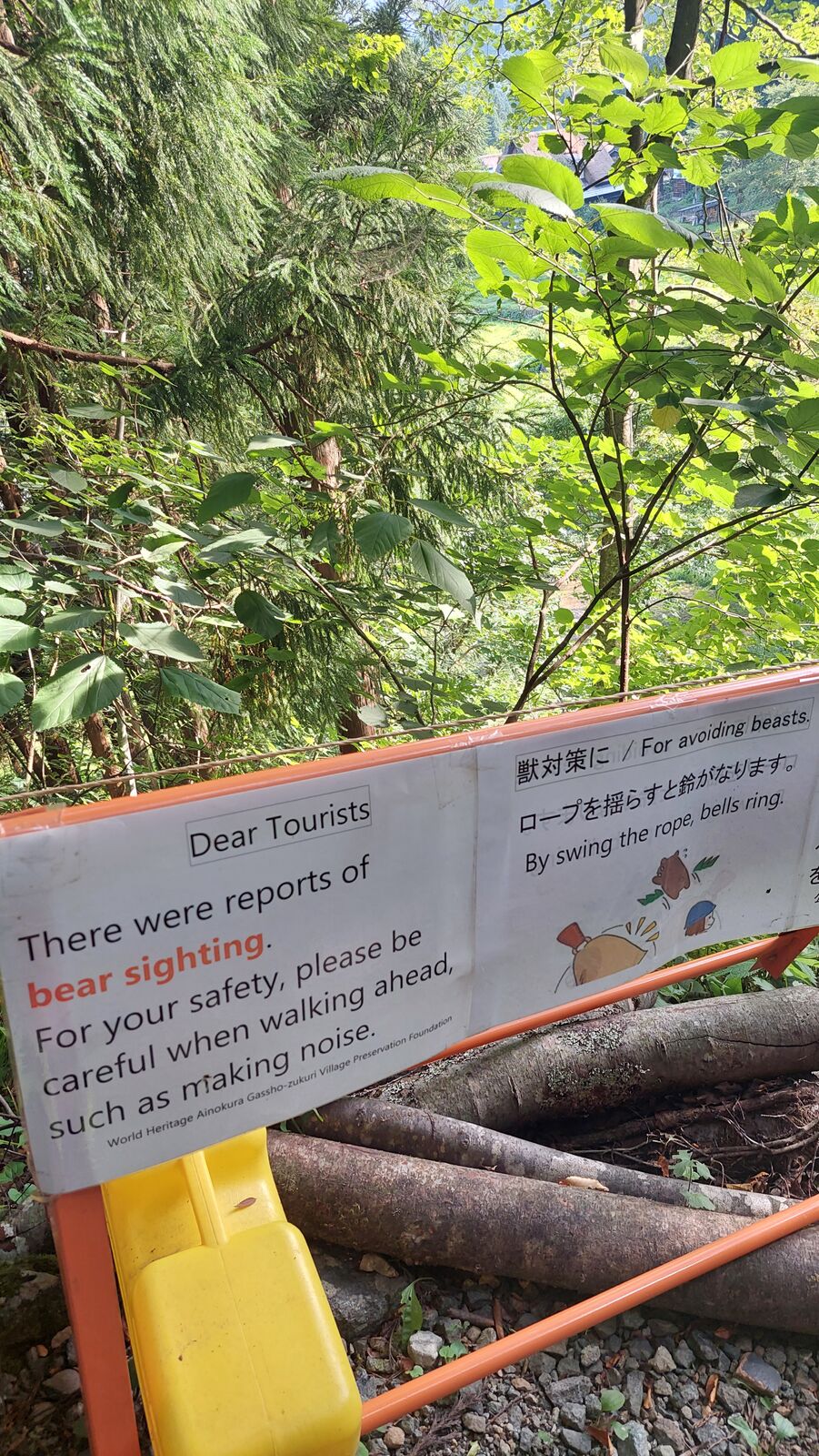 Bear warning sign at the entrance reading World Heritage Ainokura Gassho-zukuri Village