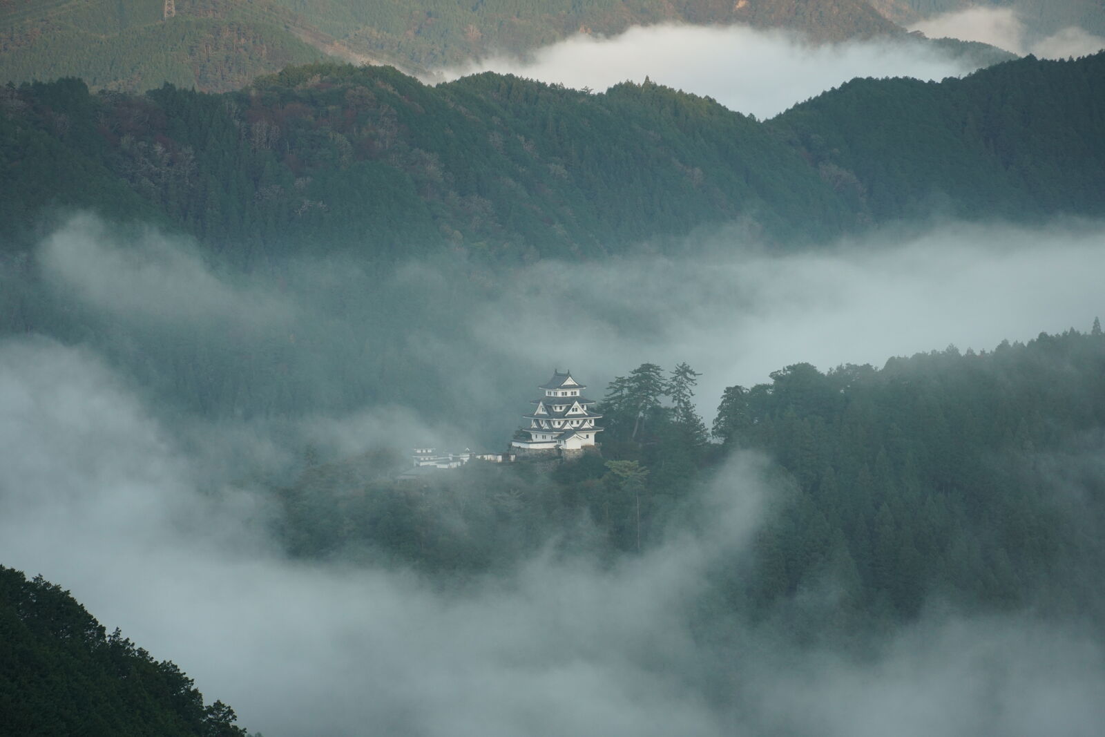Castle with flowing clouds streaming past in the early morning light