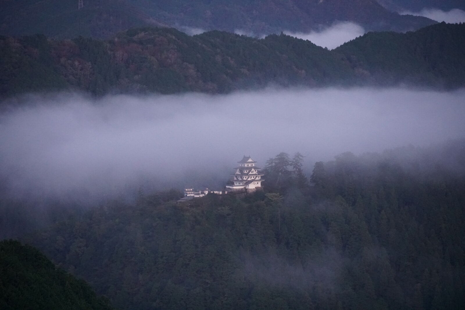 Castle visible through a moody gap in the swirling clouds