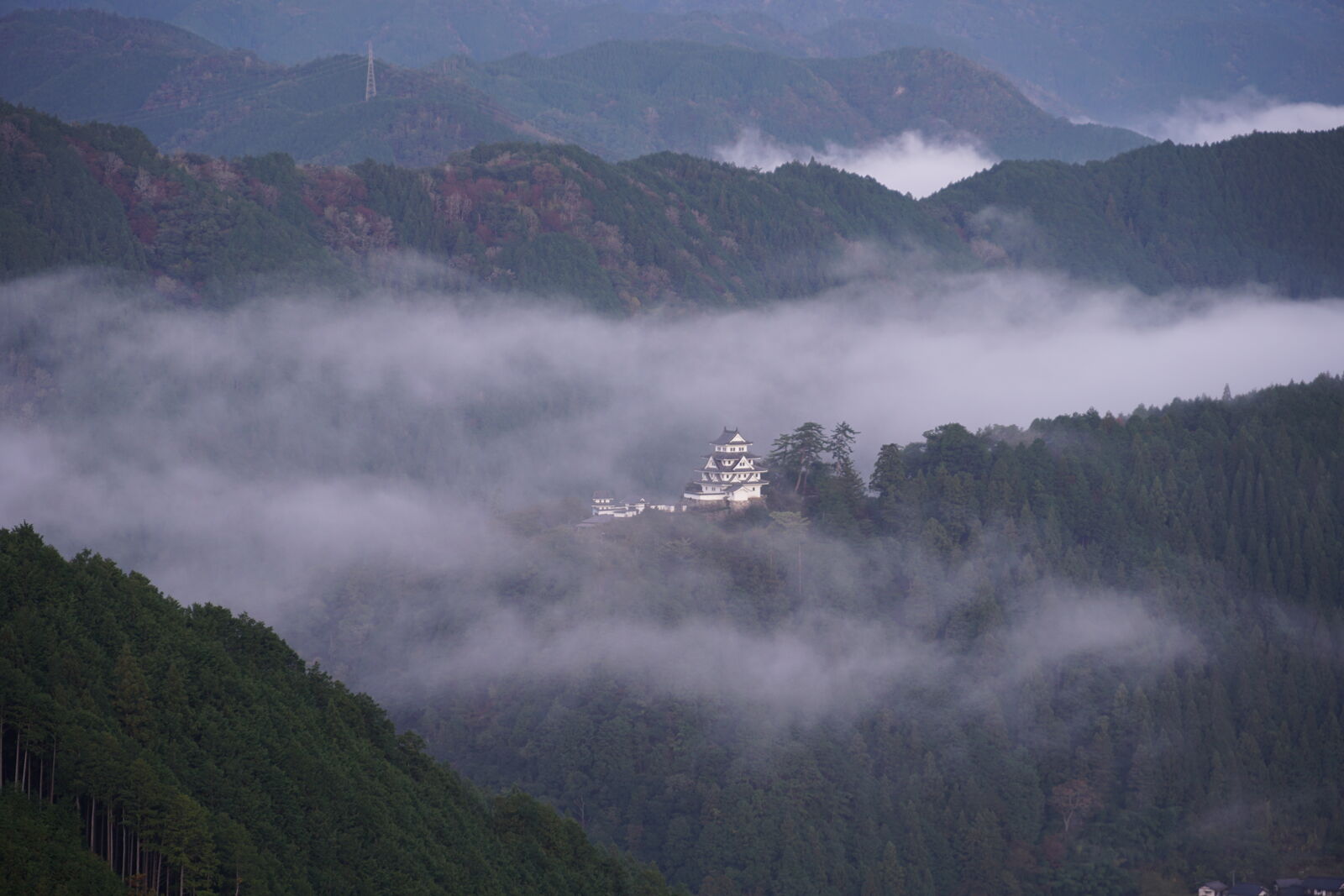 Clouds flowing past the castle like a river of white around the mountain peak