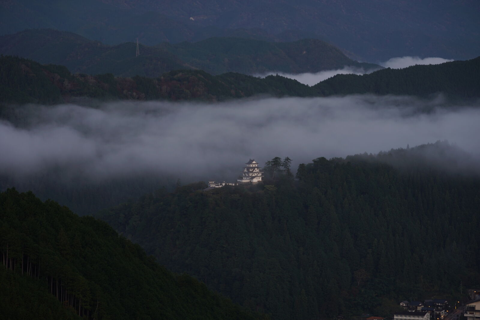 Castle silhouette against dark dramatic sky with clouds swirling below