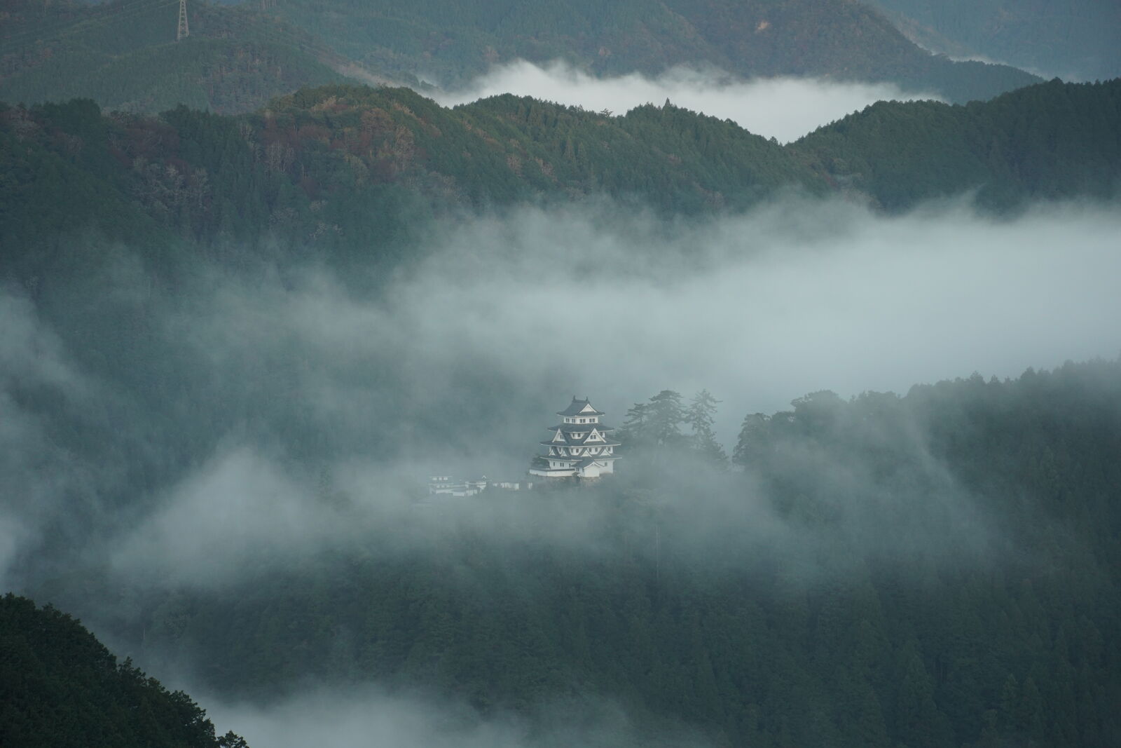 Castle framed through a narrow gap between cloud layers