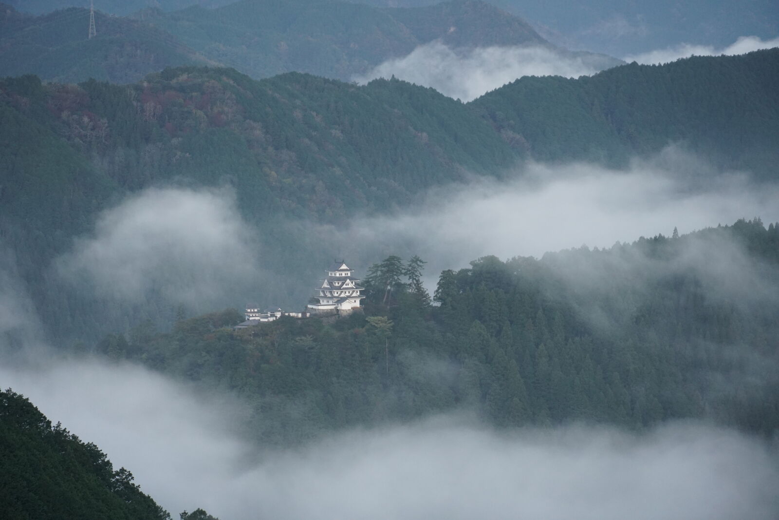 Castle prominent on its mountain ridge above the expansive cloud sea