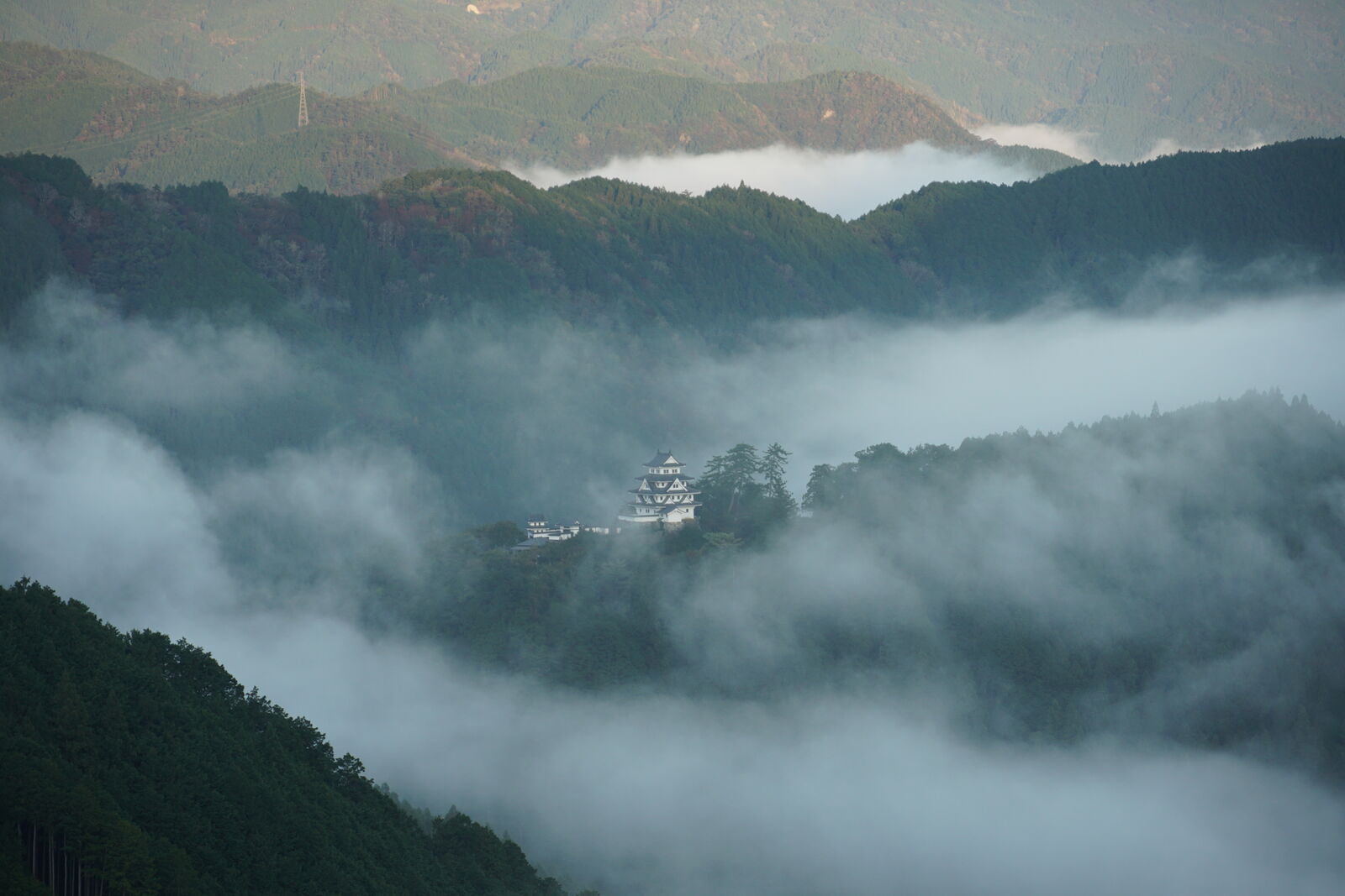 Wide view of the mountain valley with cloud remnants settling between the ridges