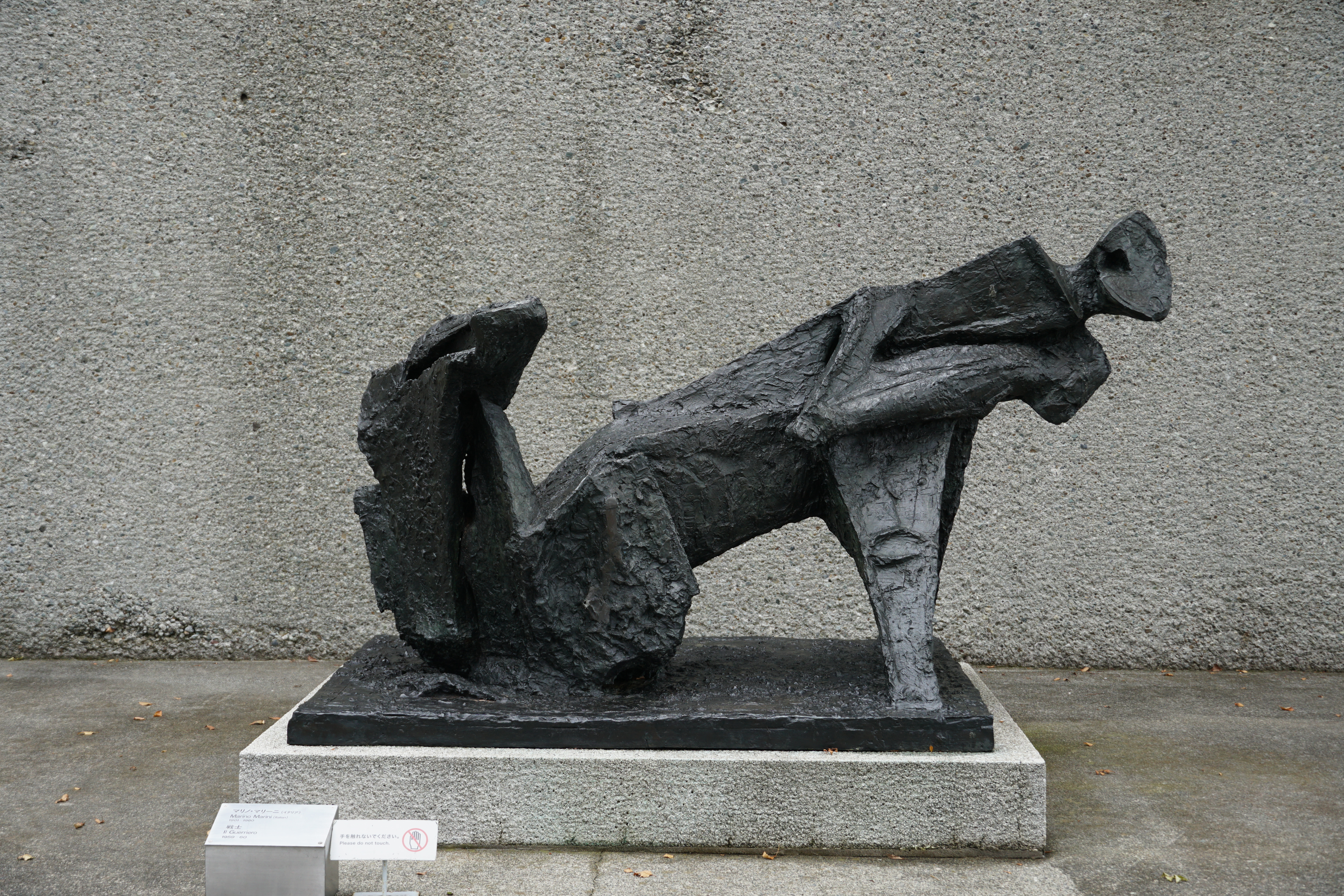 Dark bronze abstract reclining sculpture on pedestal