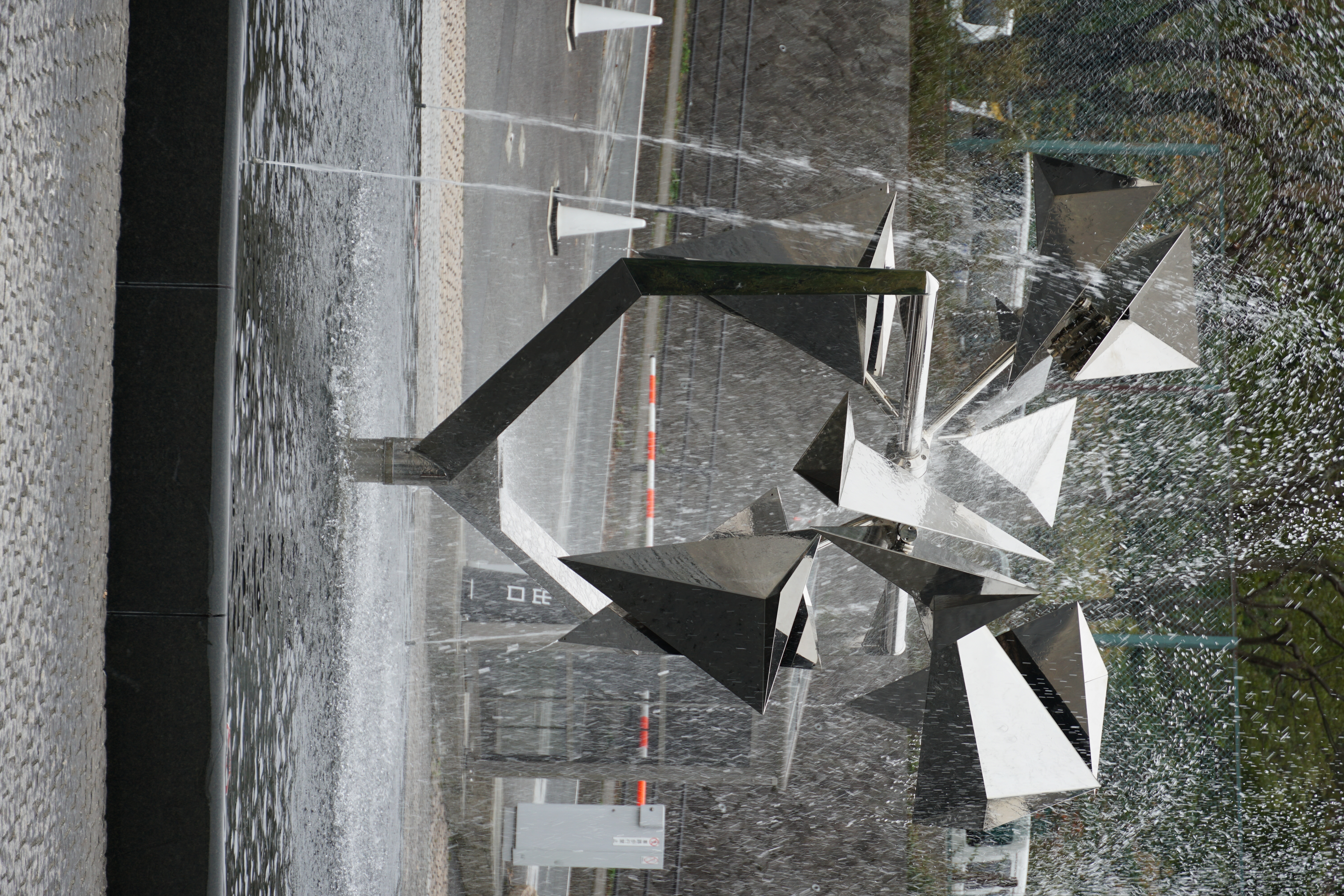 Close-up of angular metallic fountain sculpture with water
