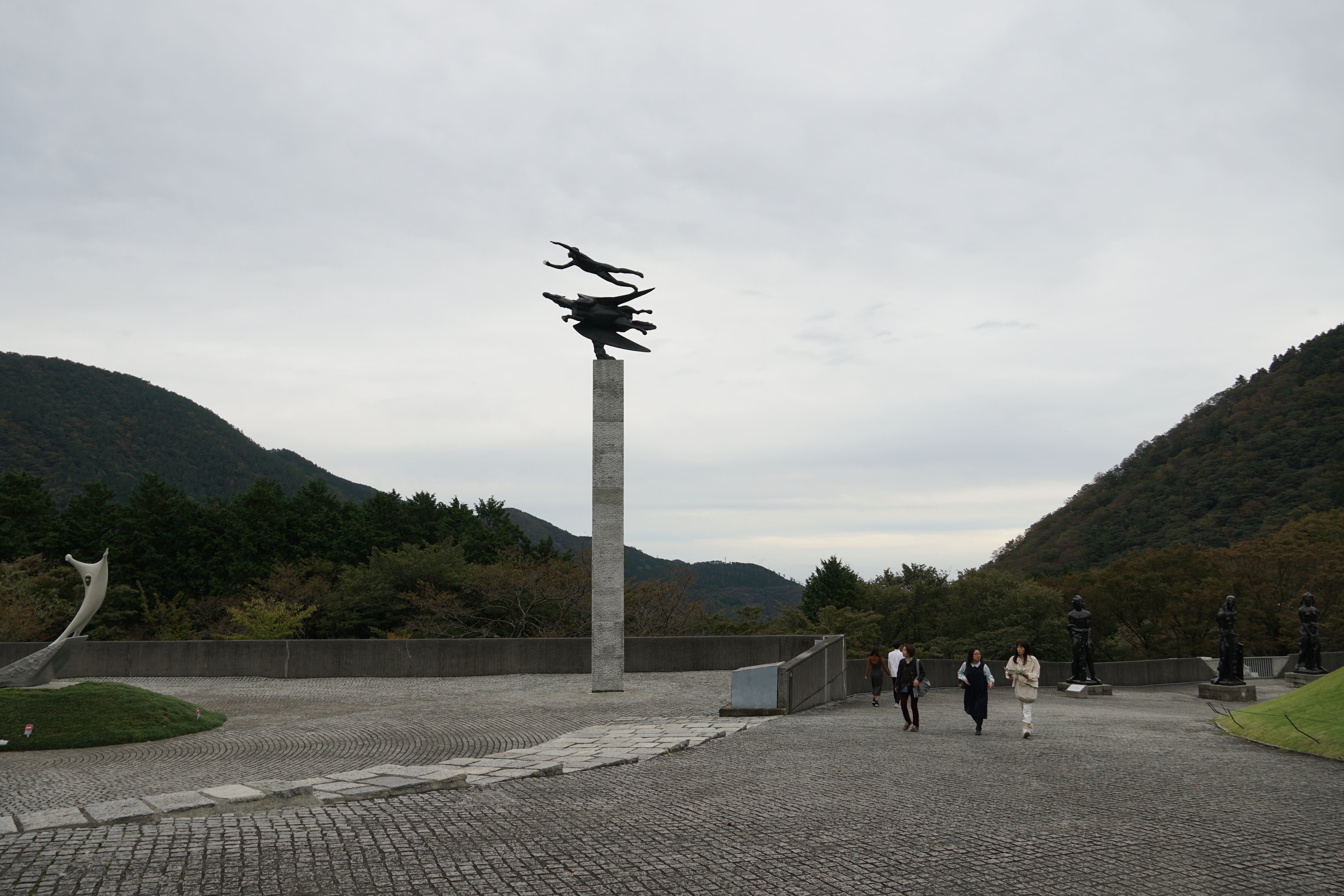 Black sculptural figures on monument with mountain vista behind