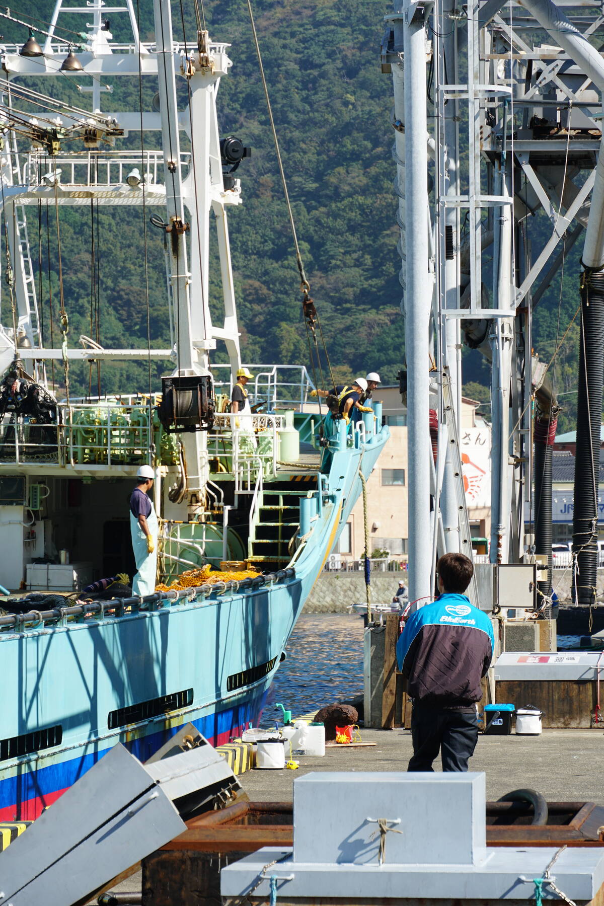 Close detail of wooden fishing boats moored together at Heda dock, their rigging and hulls worn by years of use