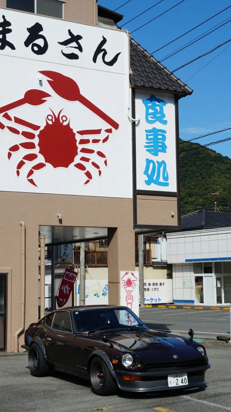 A black Datsun Z parked in front of the Marusan crab restaurant in Heda, JDM car culture meets fishing village life