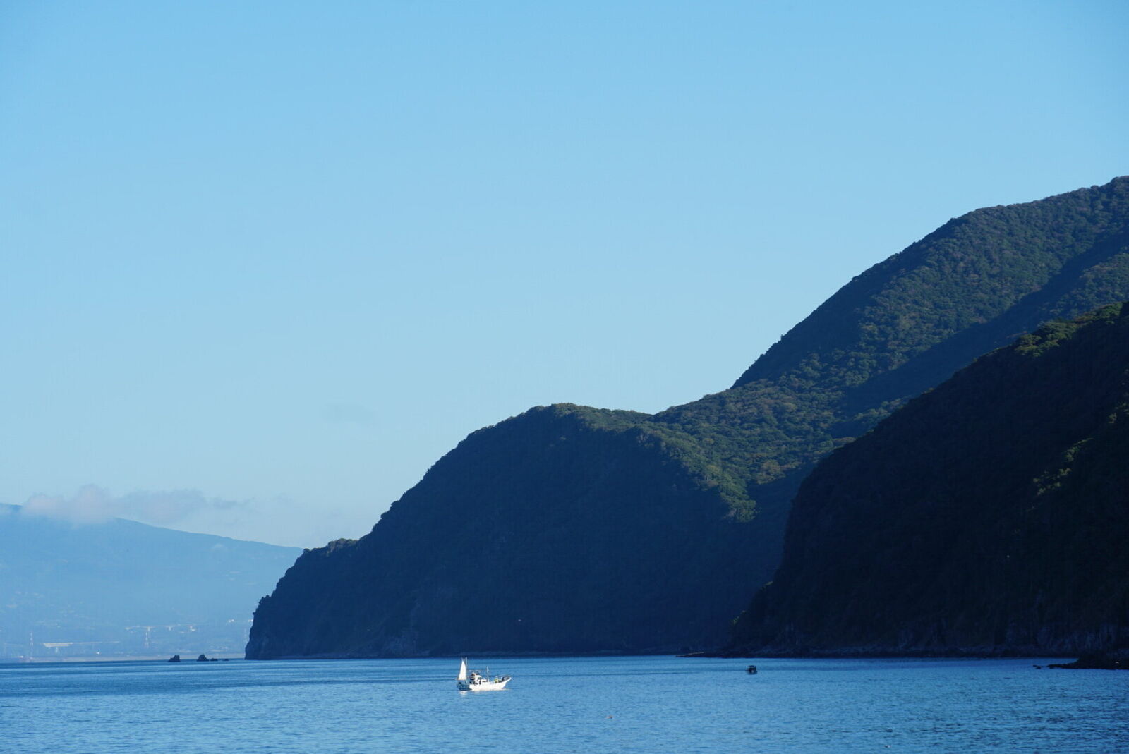 The Izu west coast on the drive to Heda: rocky sea stacks, dramatic cliffs, and deep blue water stretching to the horizon