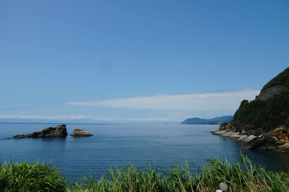 Elevated view of Heda village and harbour with fishing boats and surrounding forested hills