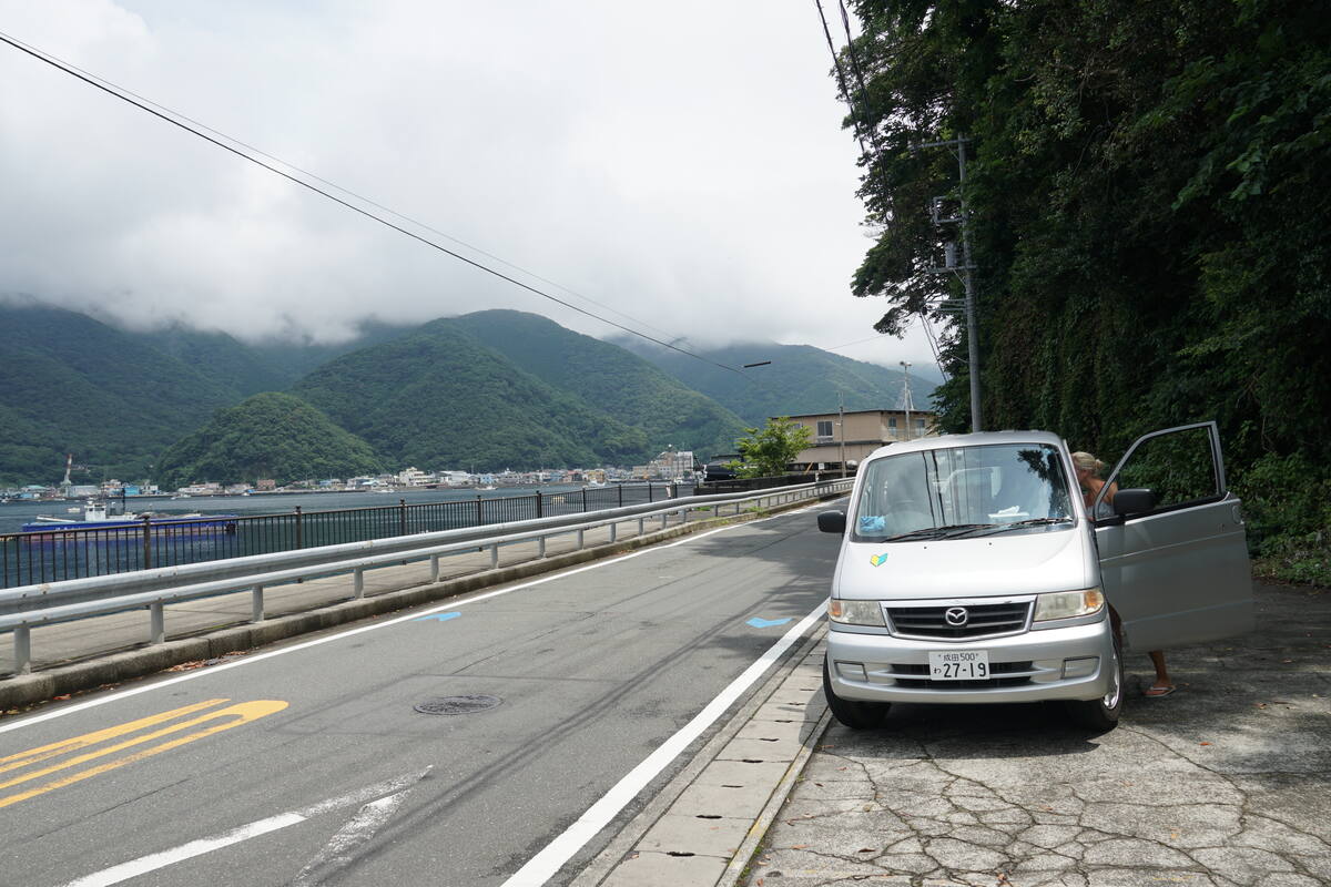 Serene morning scene at Heda waterfront with boats and mountains reflected in still water