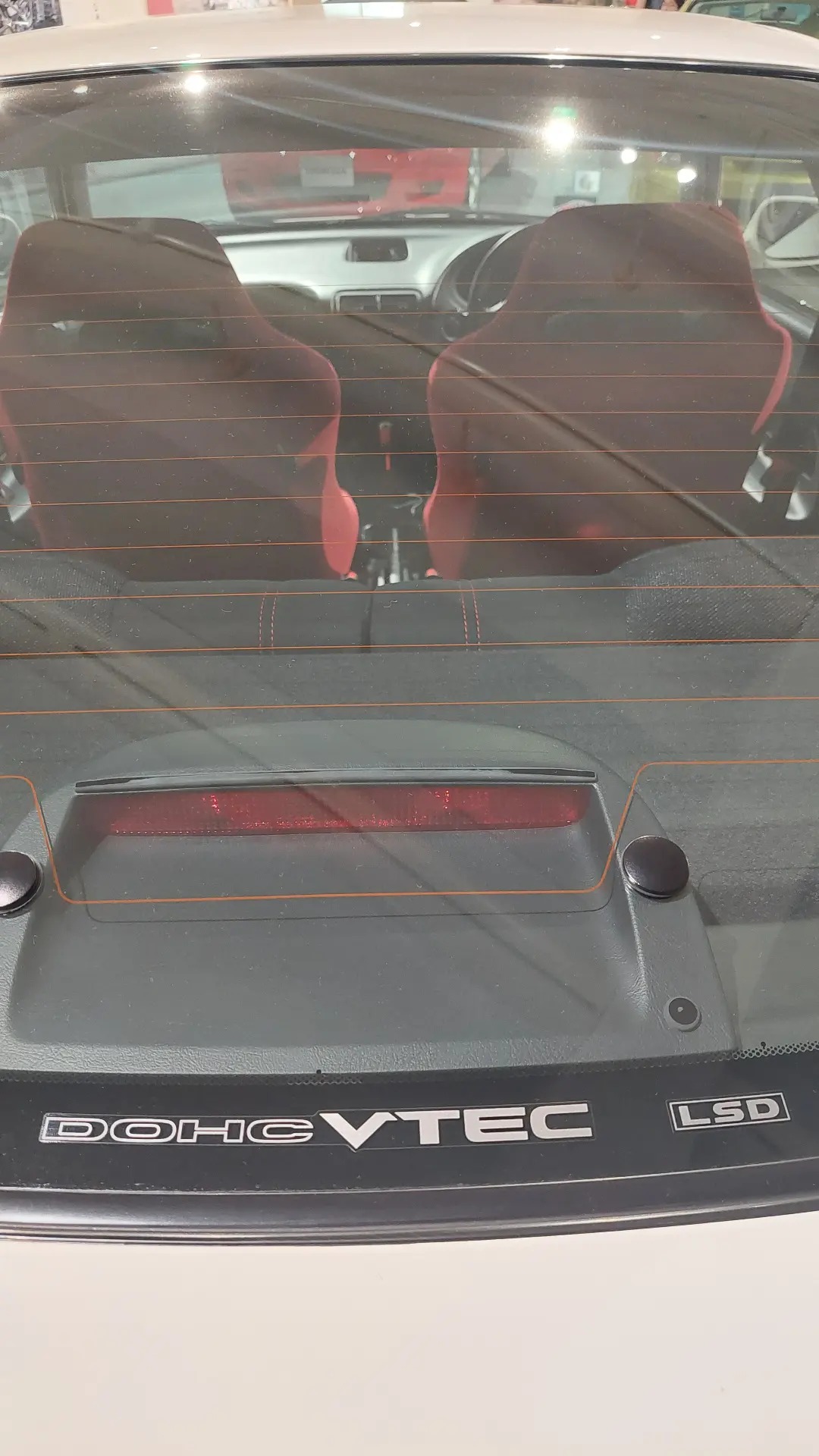 DOHC VTEC and LSD badges on the Integra Type R, red Recaro seats visible through the rear window