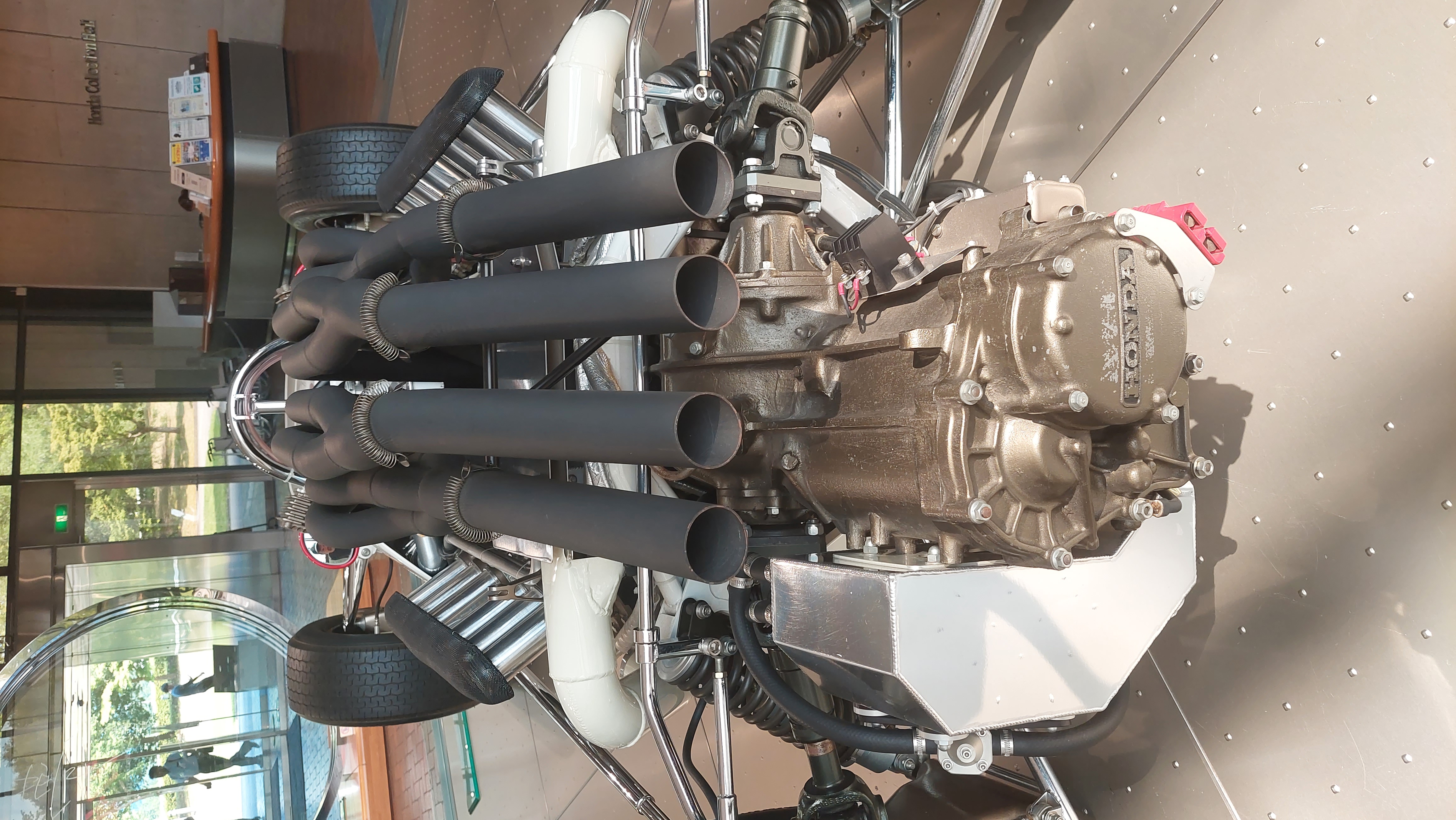 Exposed Honda racing engine with individual throttle bodies and exhaust headers, engineering as art