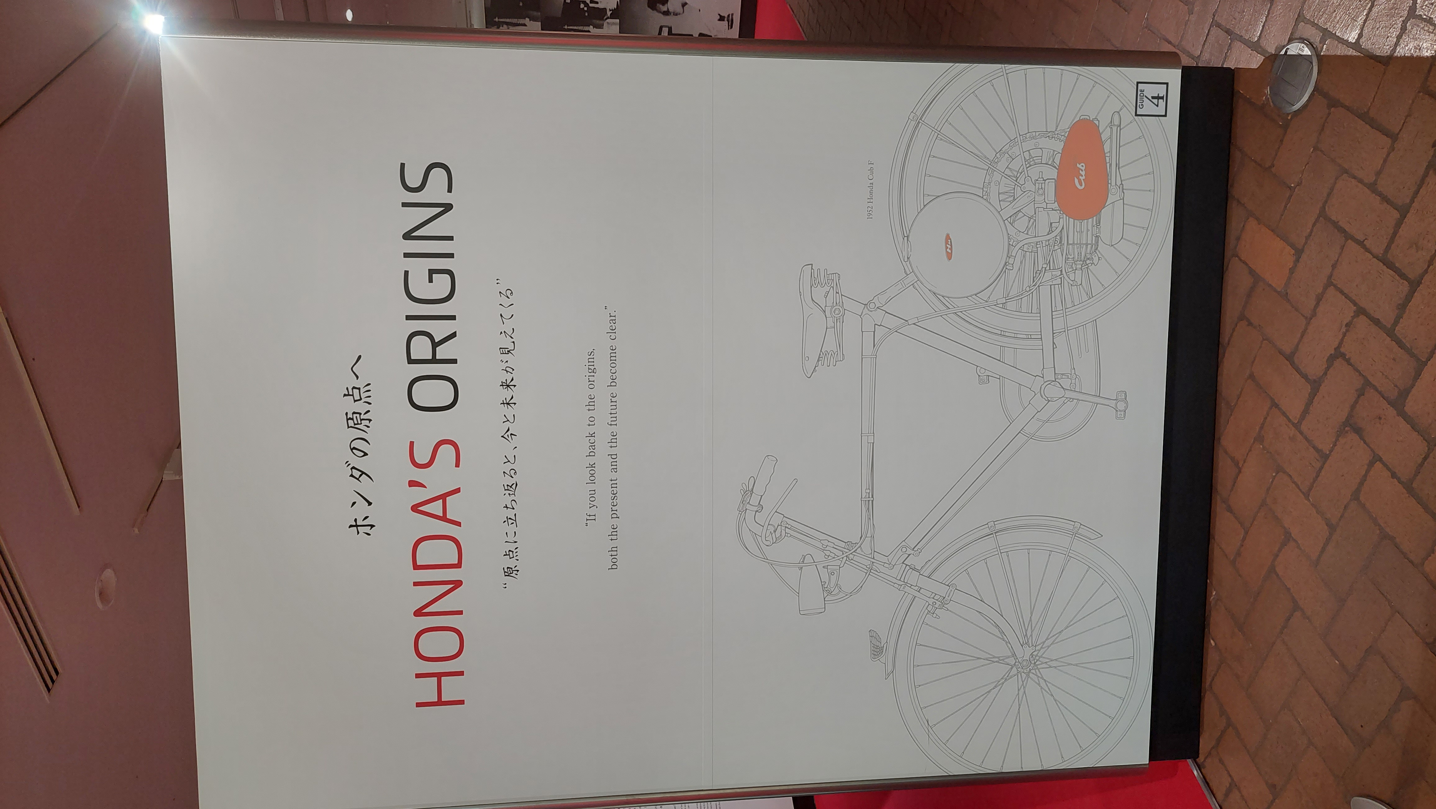 Honda's Origins exhibition panel with illustration of the 1948 motorized bicycle