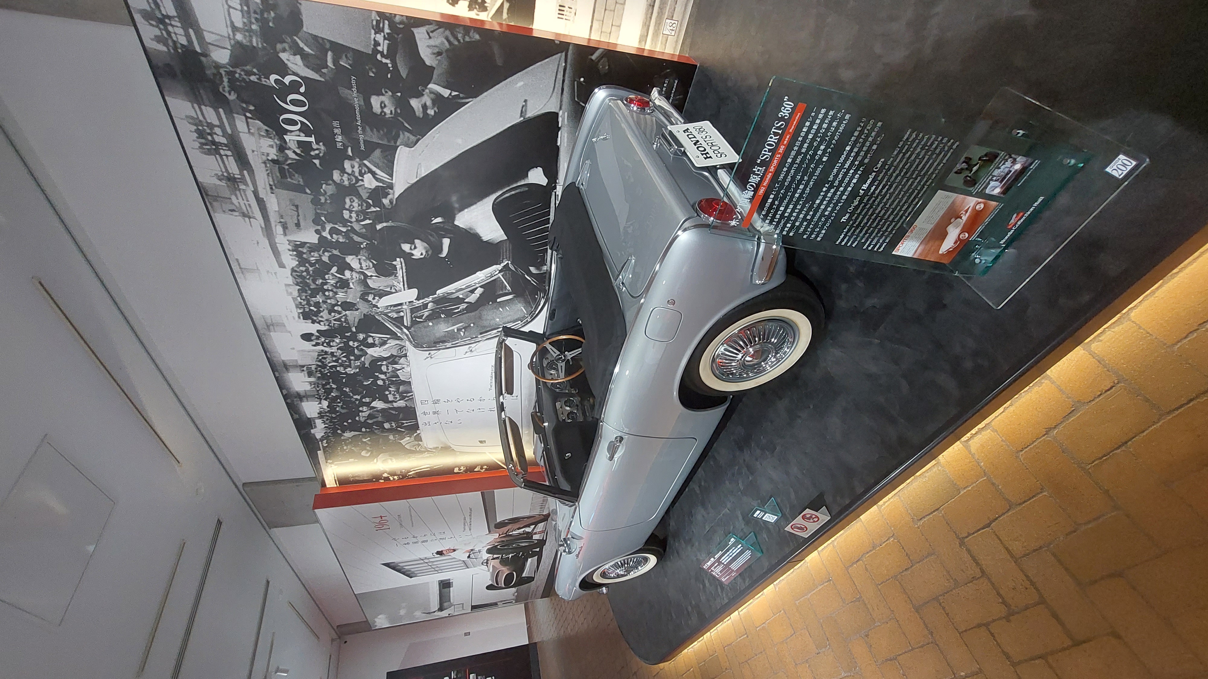 Silver Honda S500/S600 from 1963, Honda's first true sports car, displayed with period photos