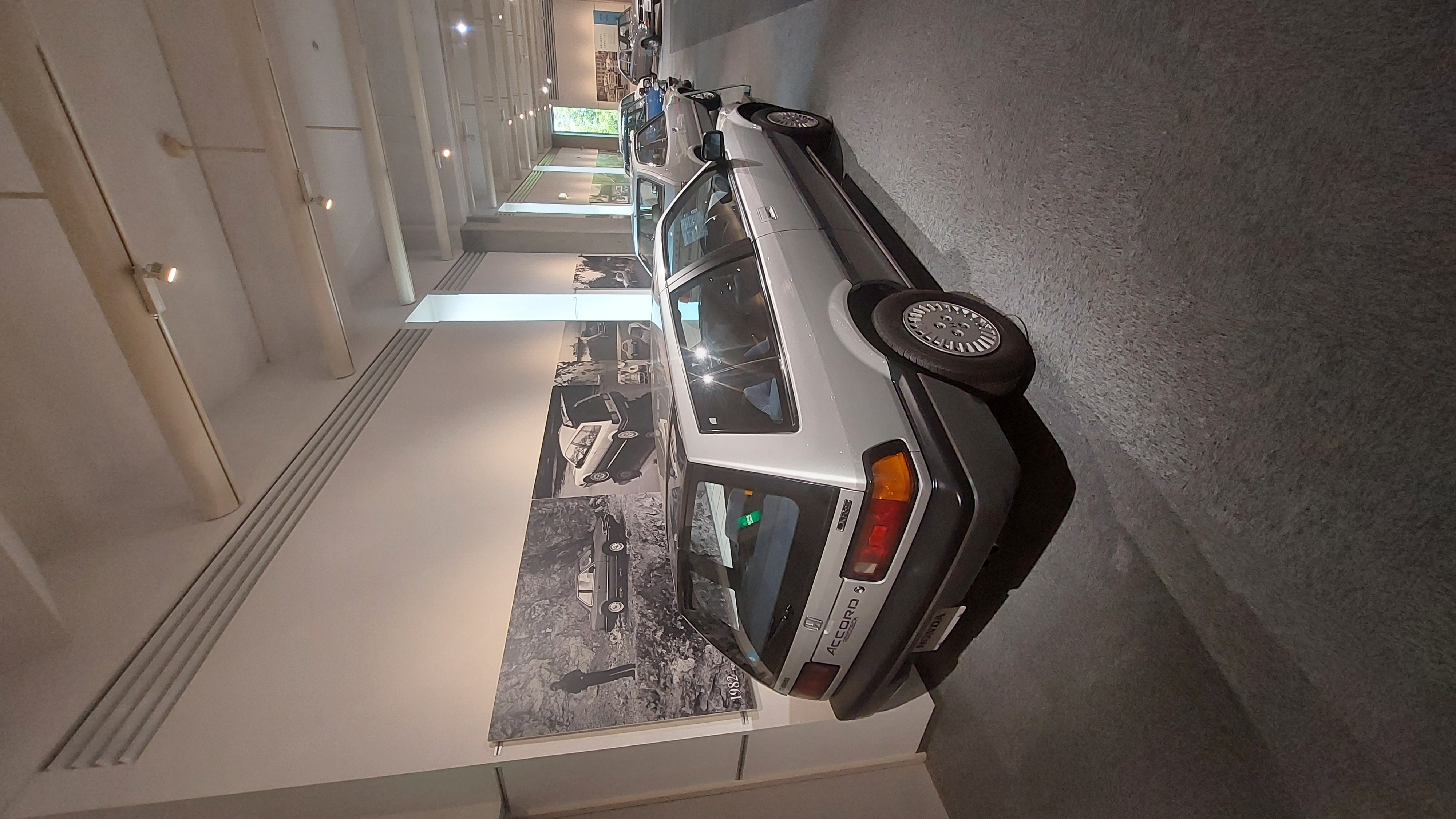 Perspective view down the car row showing the evolution from kei cars to sedans
