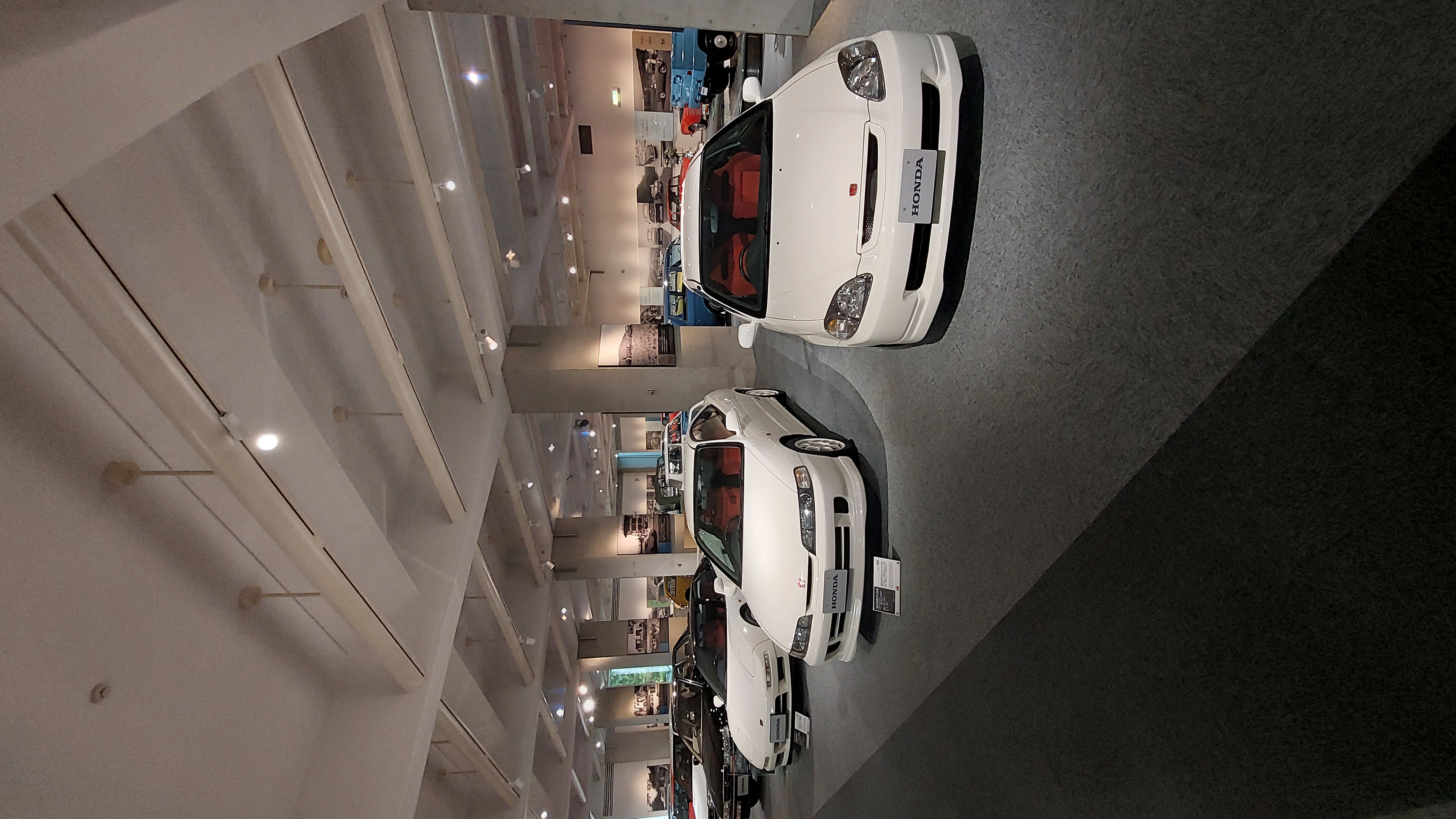 Two white Type R cars side by side on the showroom floor, Integra and Civic