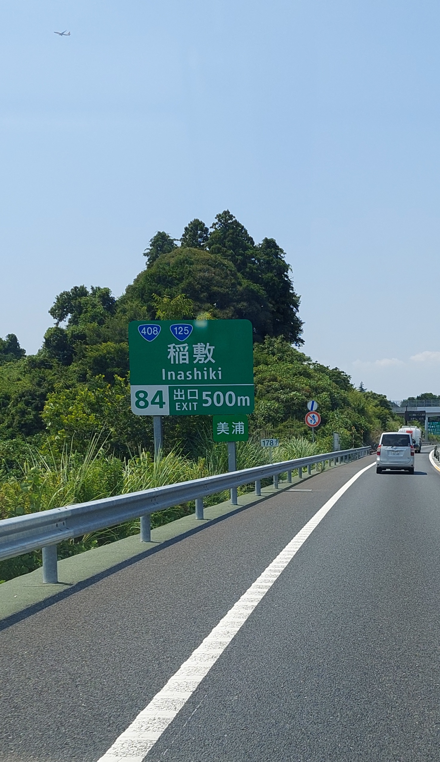Highway sign for Inashiki exit on the drive to Motegi, summer sky over Tochigi