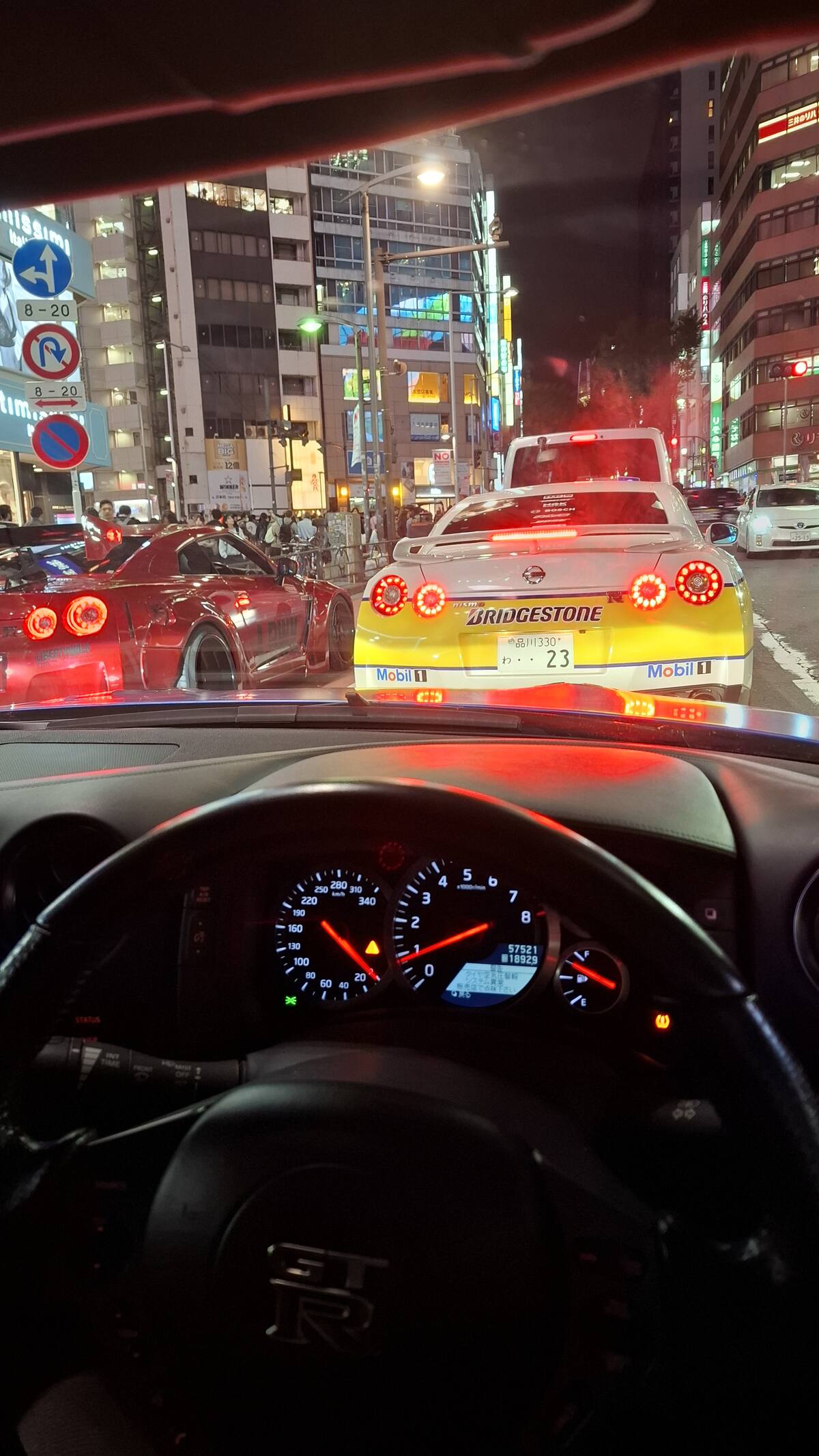 GT-R dashboard and tachometer with Bridgestone #23 GT-R ahead in the Shibuya convoy