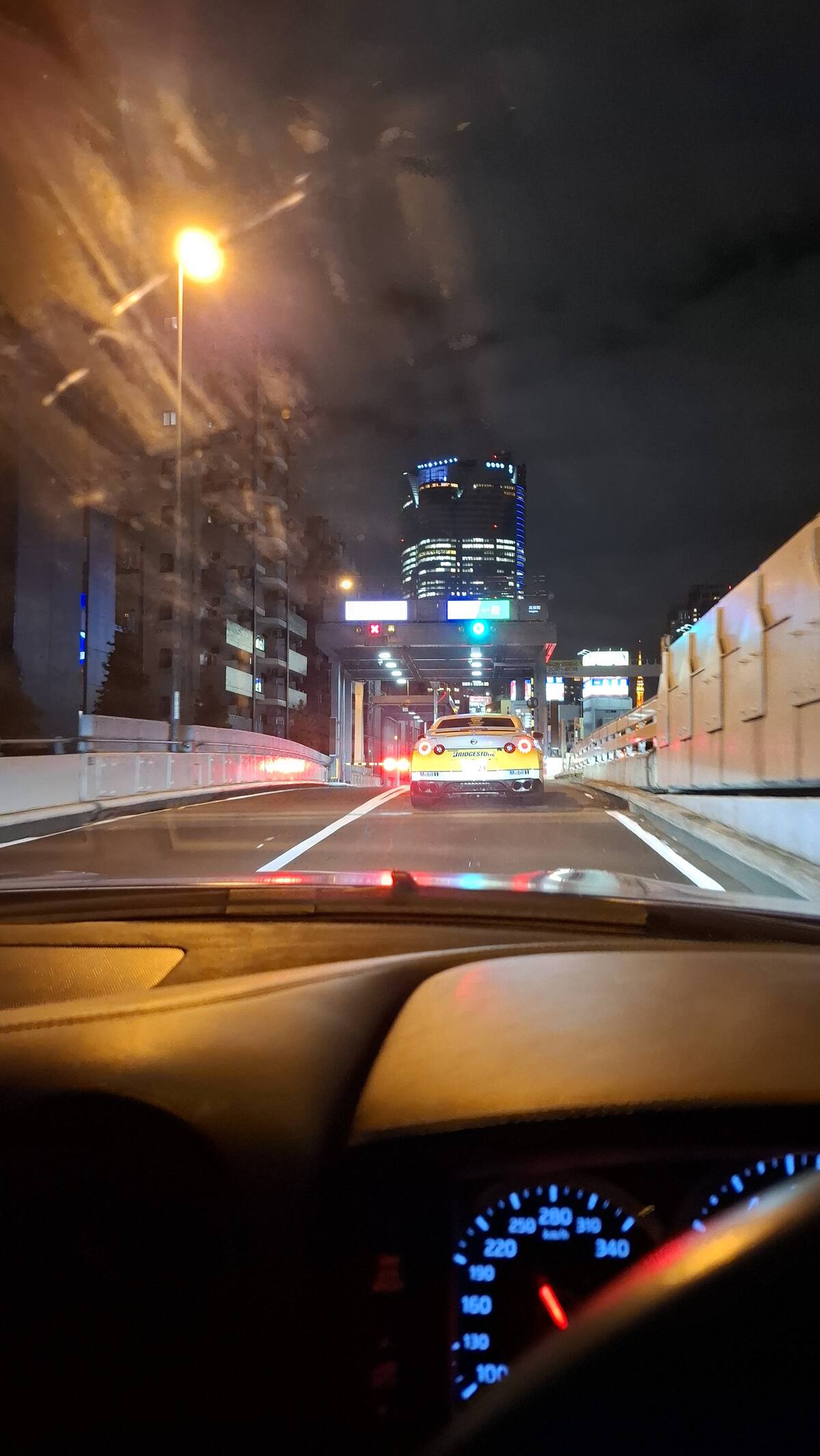 Entering the Shuto Expressway on-ramp between illuminated buildings