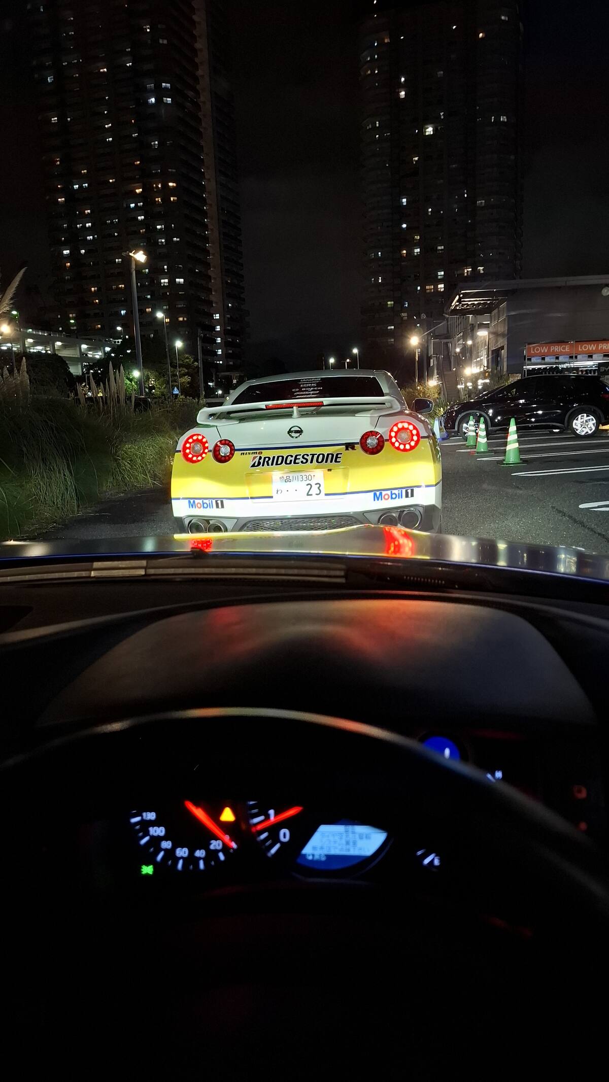 Dashboard view following #23 with city lights reflected