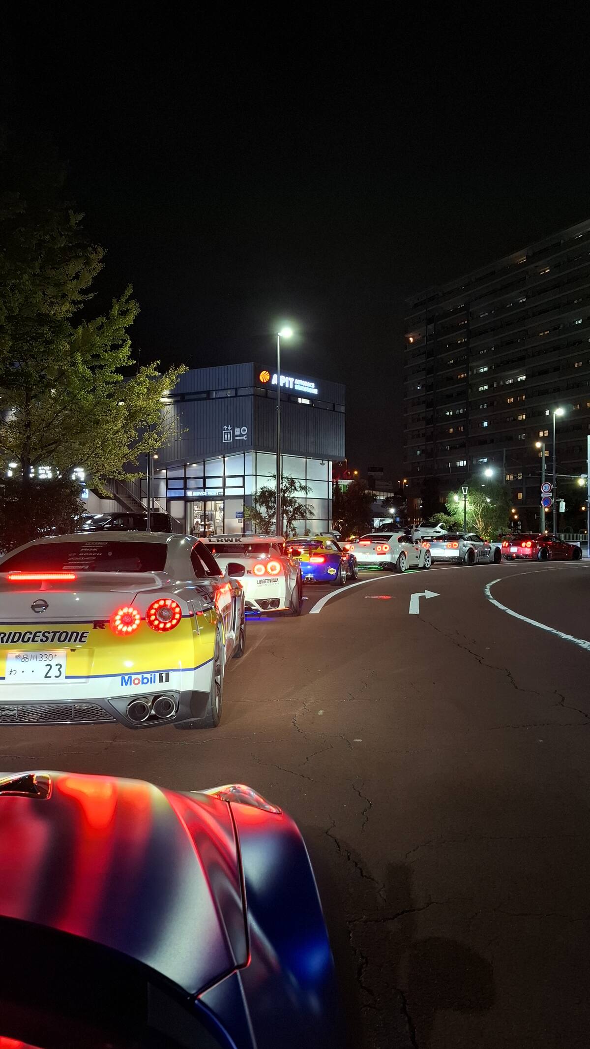Long line of tour cars on a Tokyo street at night