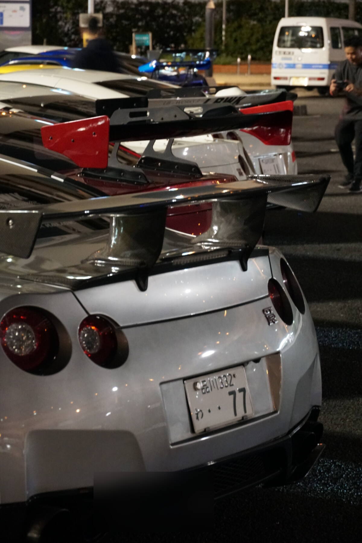 Lineup of GT-R rear ends with carbon fiber spoilers at Daikoku