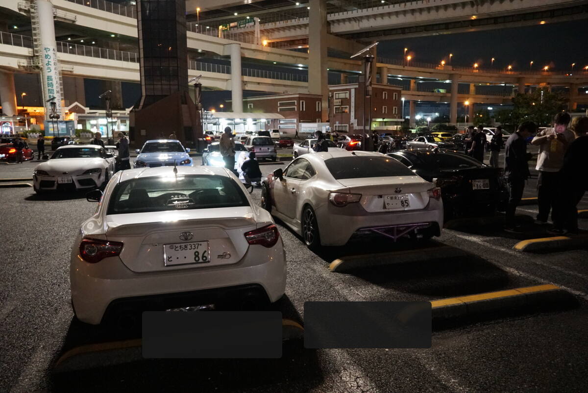 Daikoku PA car meet scene with Toyota 86s, GT-Rs, and car enthusiasts