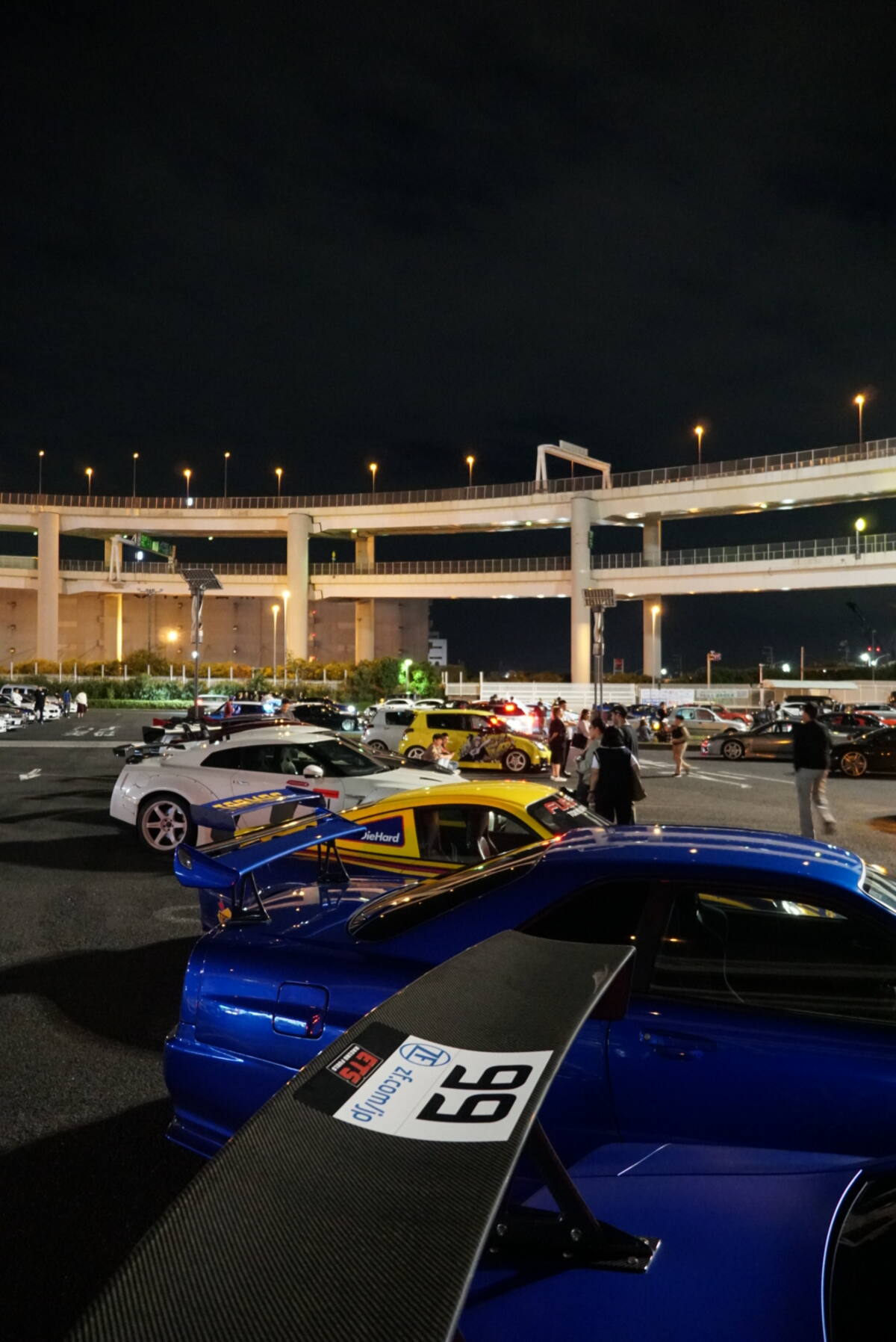 Blue GT-R #99 with the Ichioku fleet at Daikoku under the highway interchange