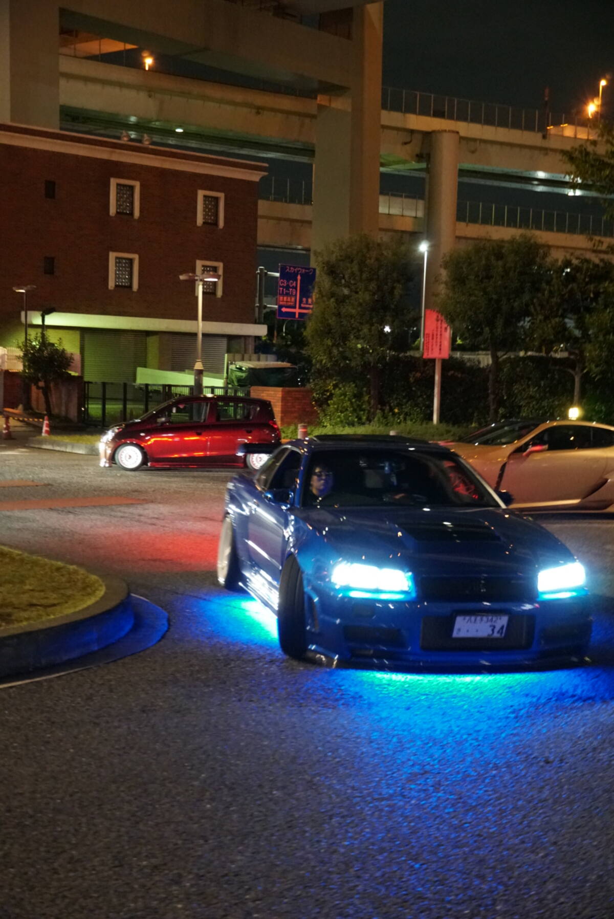 Blue GT-R with headlights on at night, ready to leave
