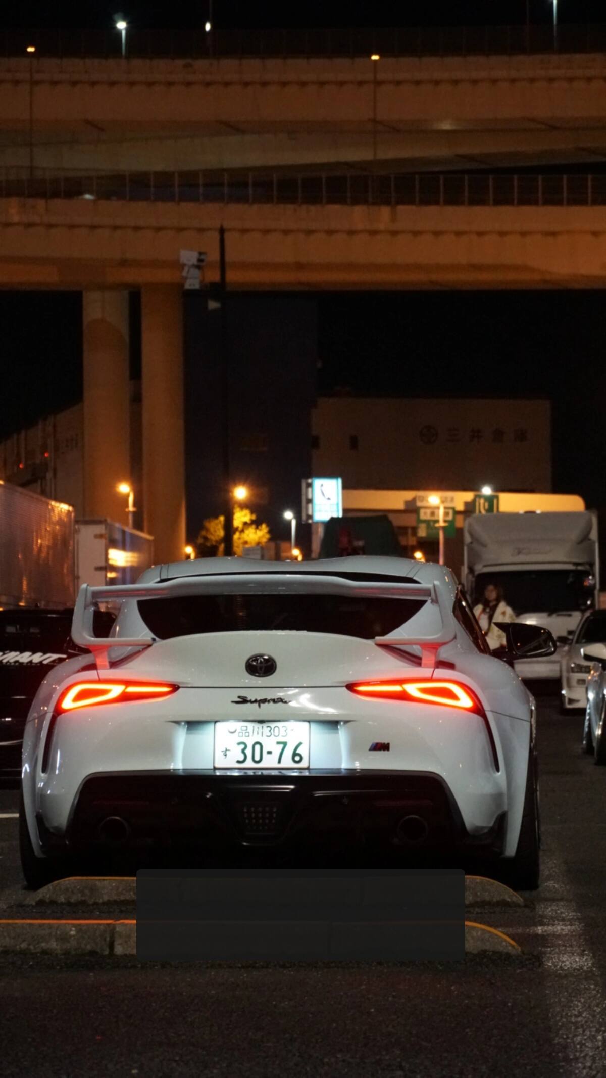 White Toyota Supra at Daikoku PA under the highway overpass at night