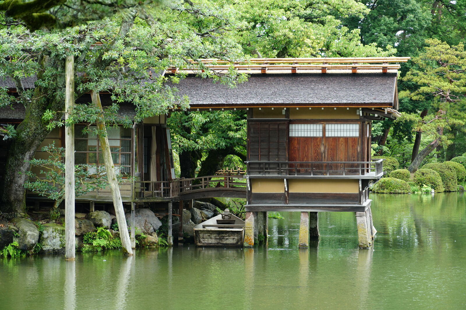 Detail of tea house stilts reflected in the pond water