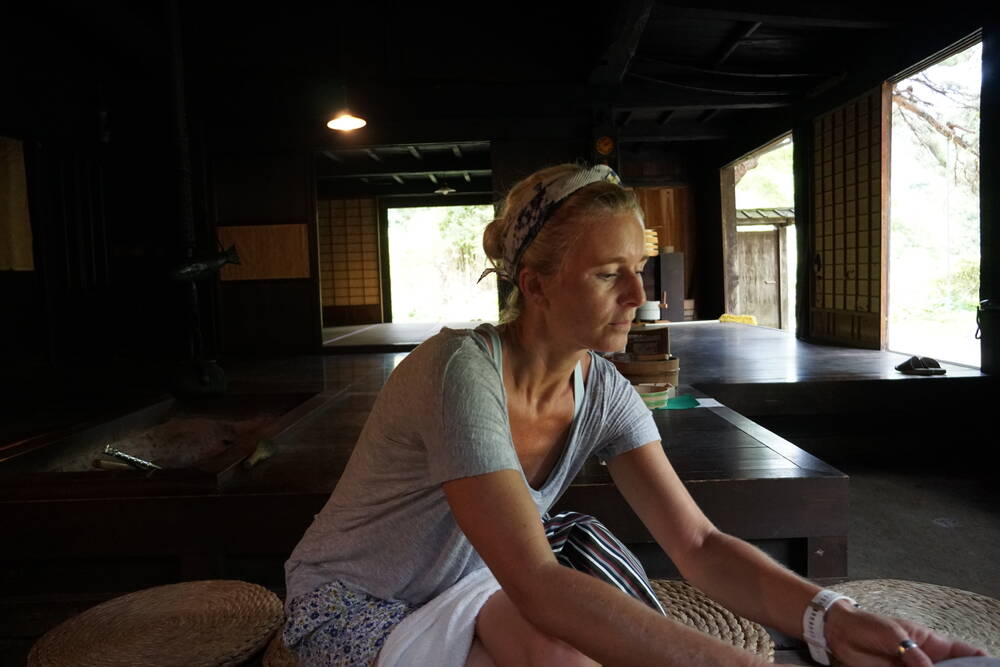 Inside a traditional post station with tatami floors, shoji screens, and warm light filtering in