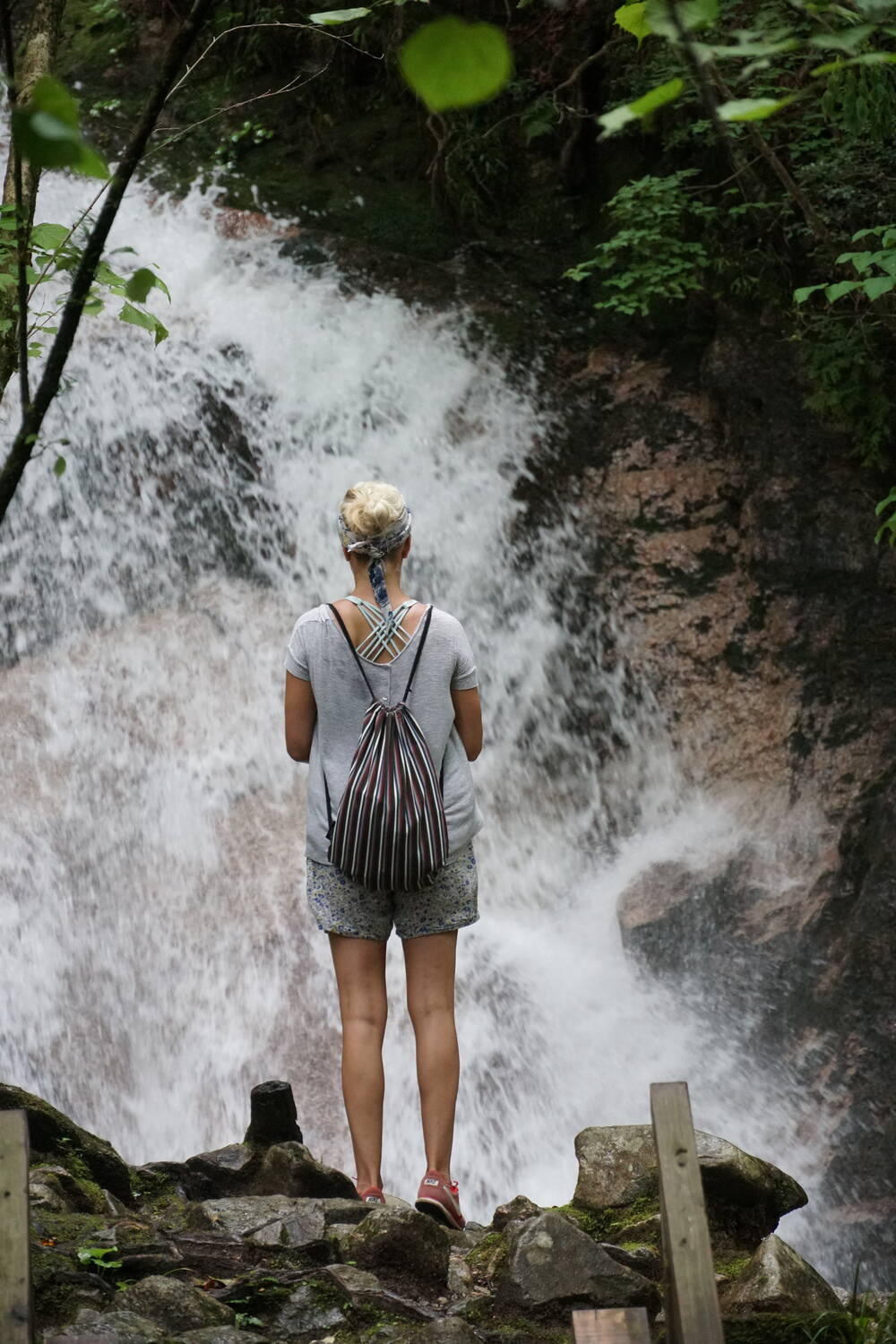 Waterfall crashing over rocks along the Nakasendo trail, surrounded by lush green forest