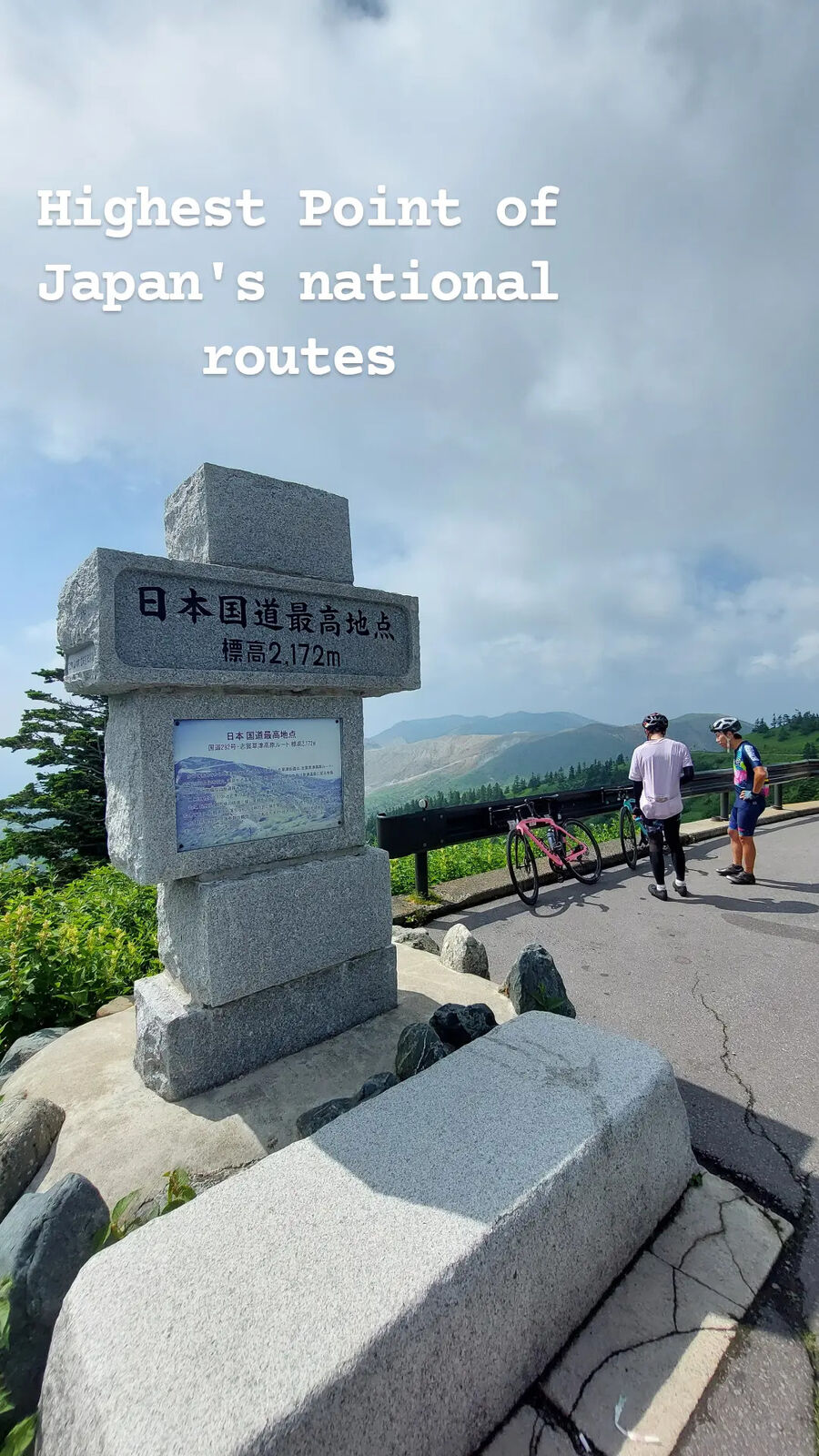 The monument with cyclists visible in the background preparing their bikes for the descent