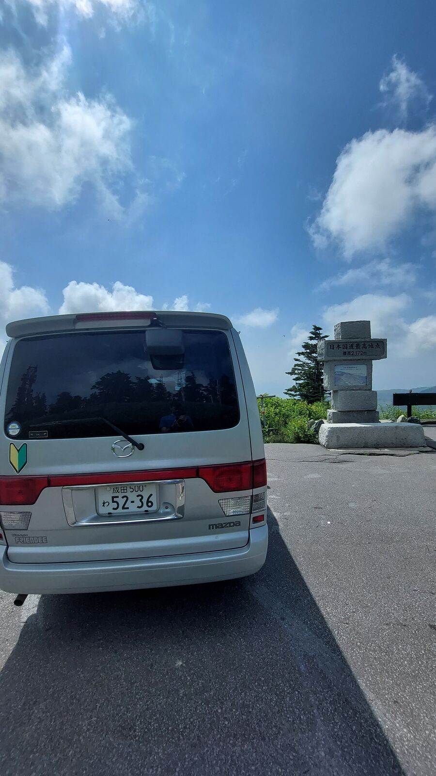 Rear view of the campervan with the highest point monument visible behind it against the sky