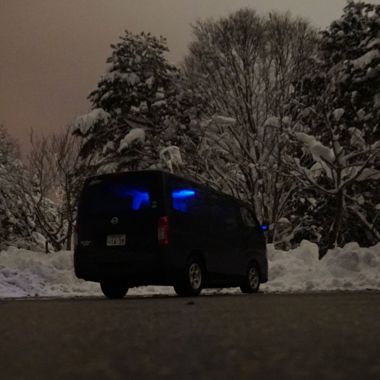 Campervan parked at the Michi-no-Eki near Shirakawa-go on a deep winter night with blue twilight sky